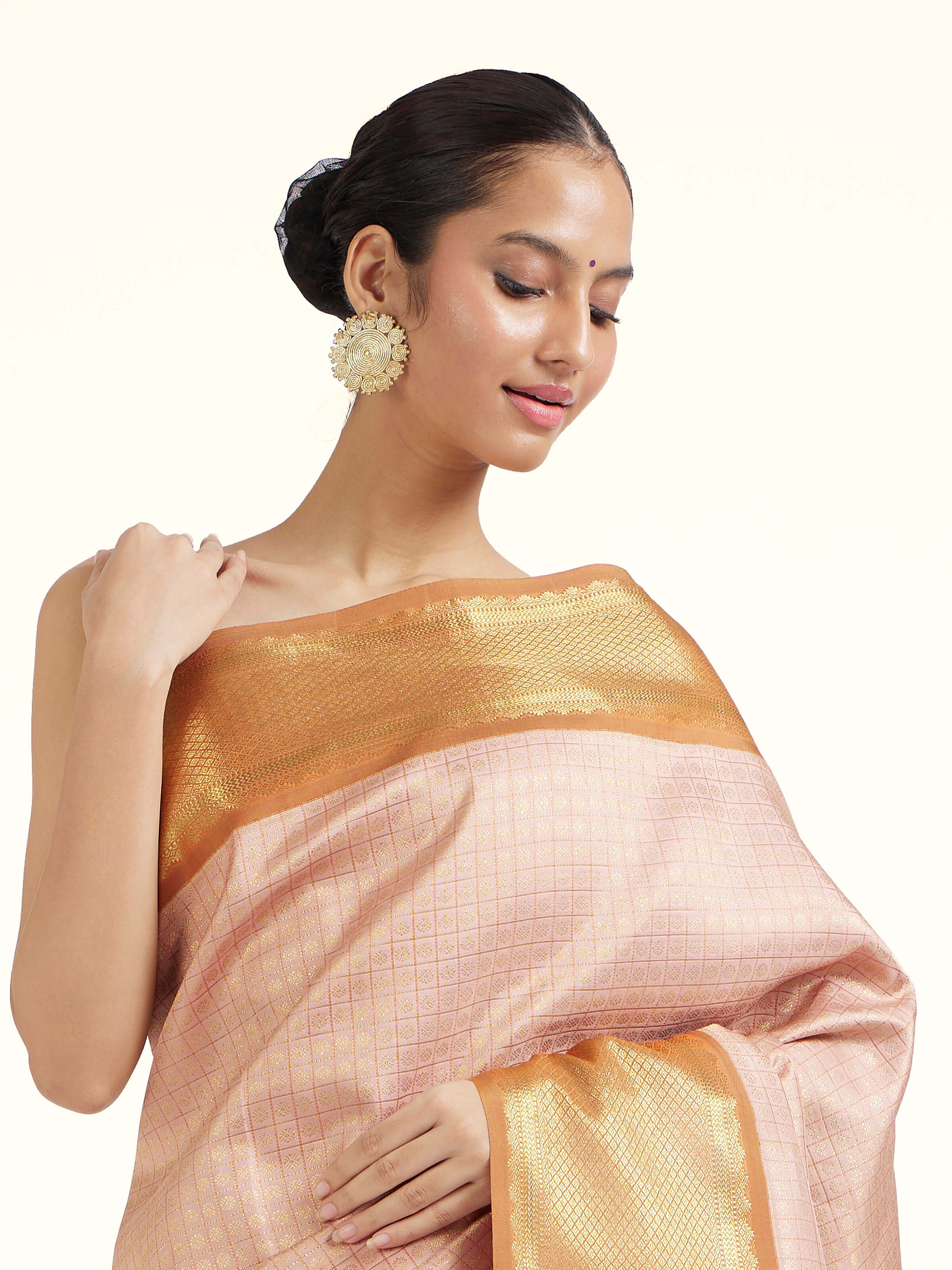 Angled view of pink silk Kancheepuram saree highlighting traditional weave and sheen