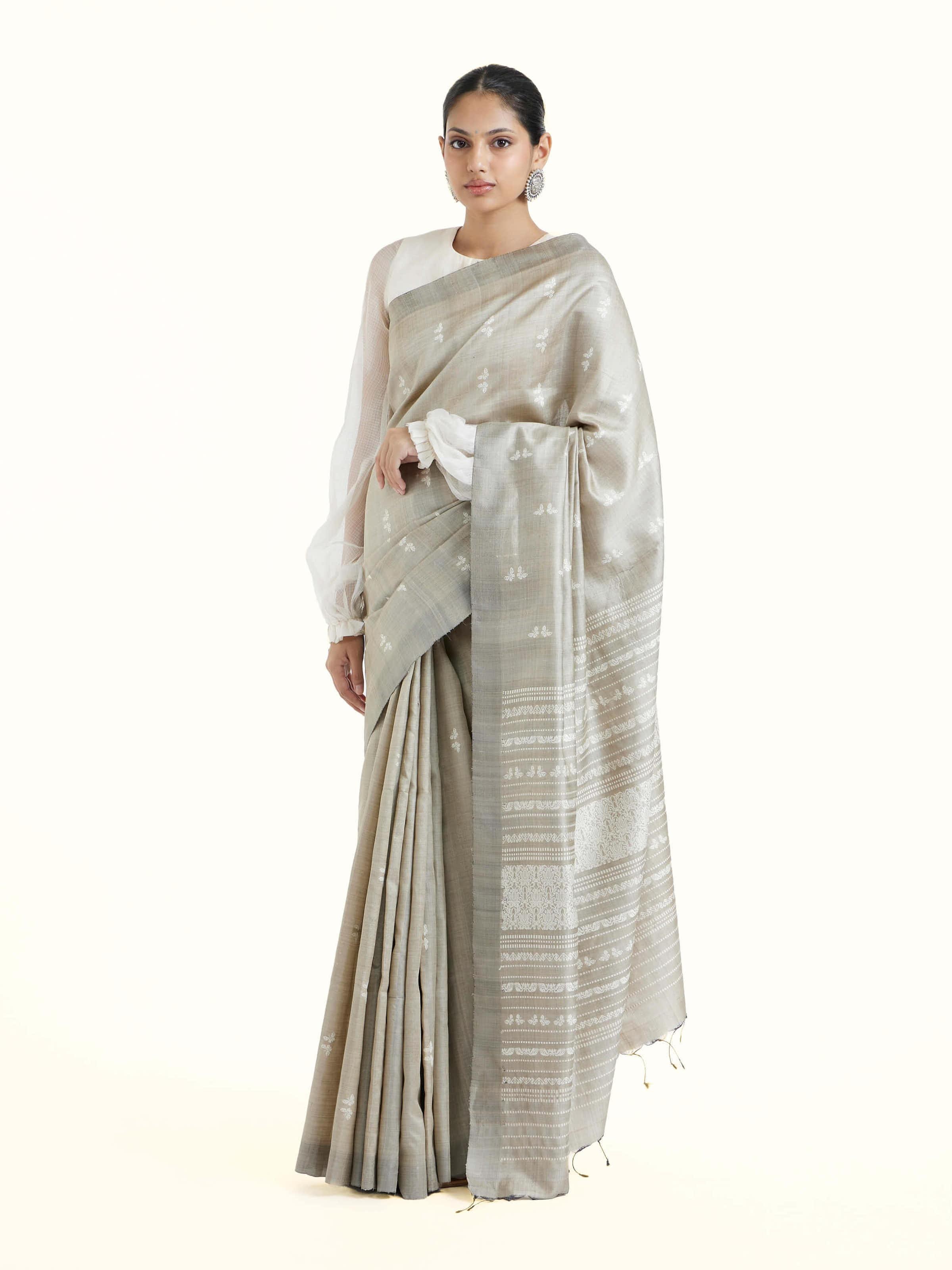 Side view of grey tussar silk Odisha ikat saree highlighting natural texture and graceful drape