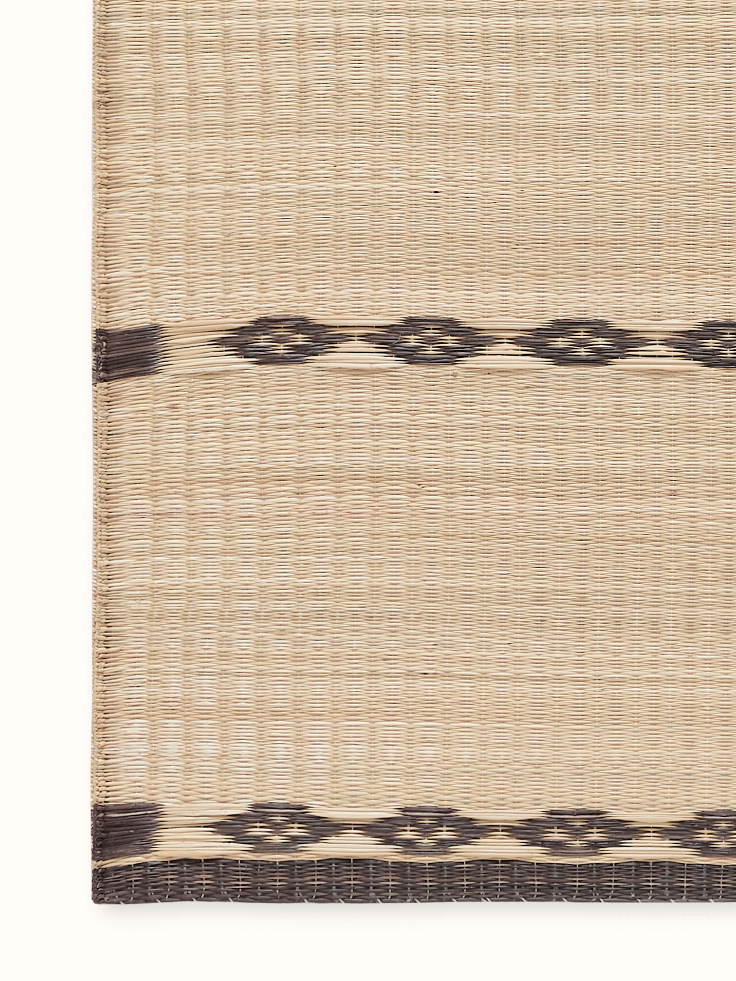 Close-up detail of Prakriti black stripe Madurkathi table runner showing intricate natural fibre weave and stripe pattern.