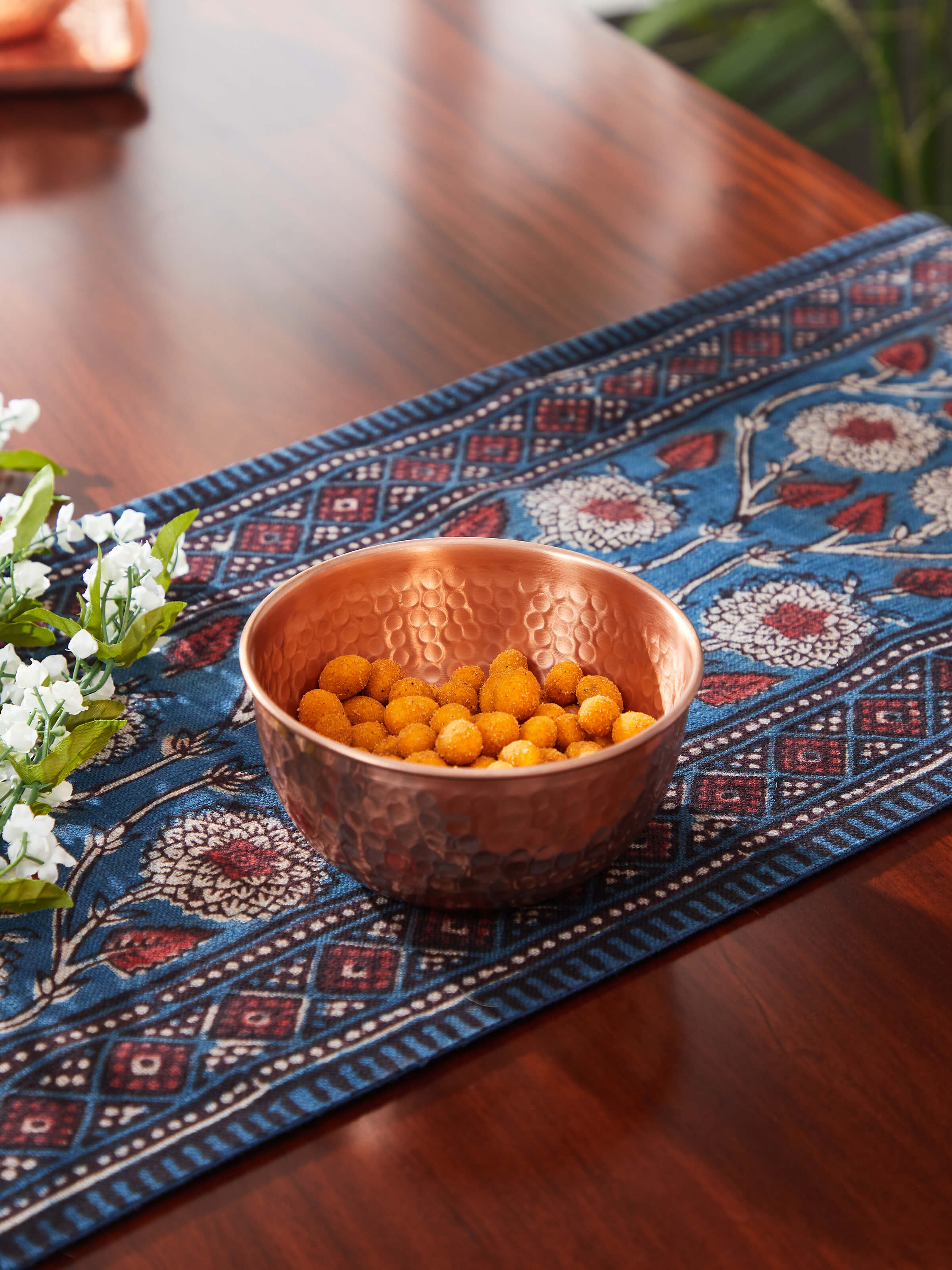 Side view of Copper Fruit Bowl highlighting its reflective surface and modern, sleek shape.