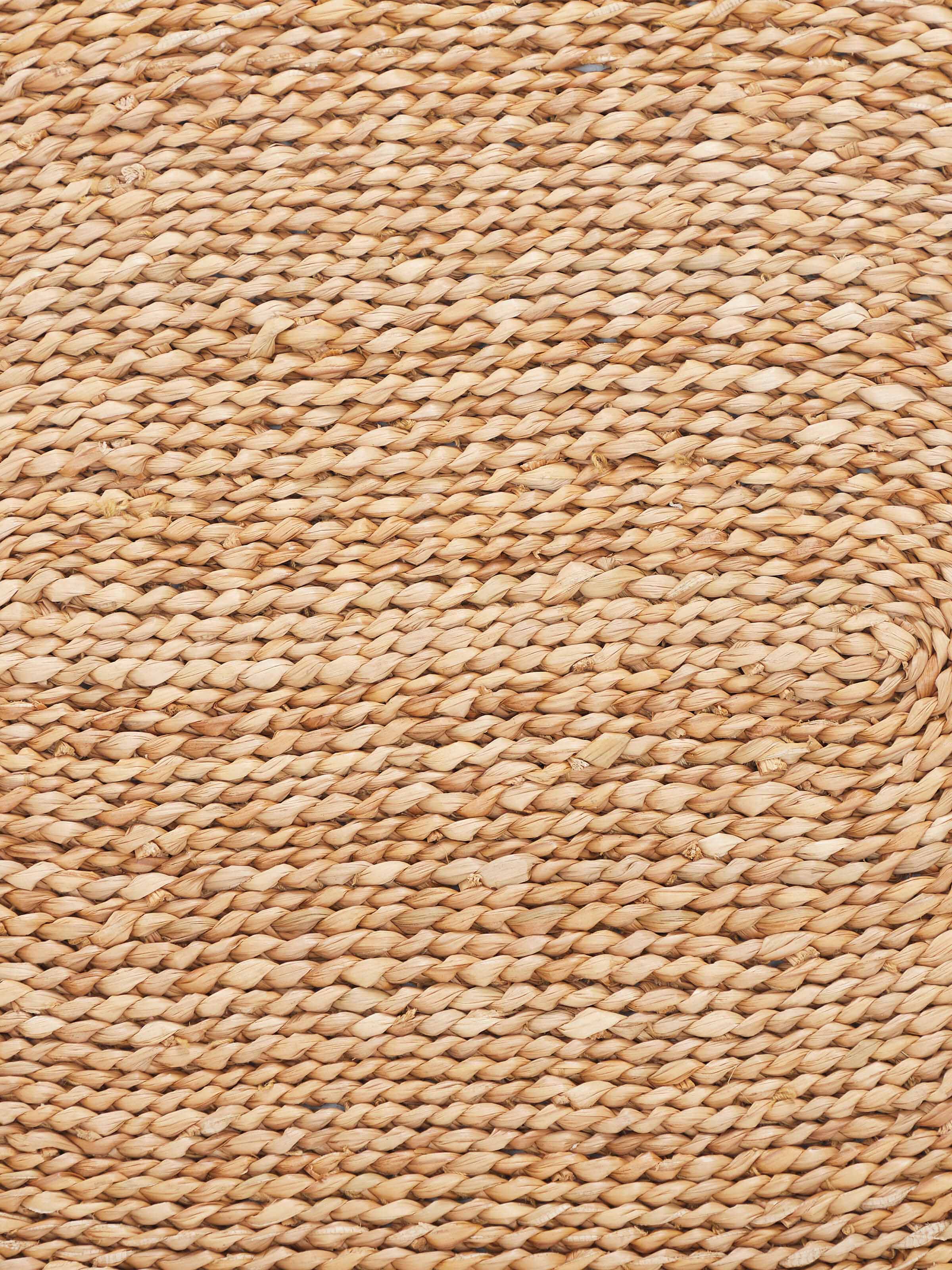 Top-down view of Vritti brown solid oval natural fibre trivets showing the texture and natural material.