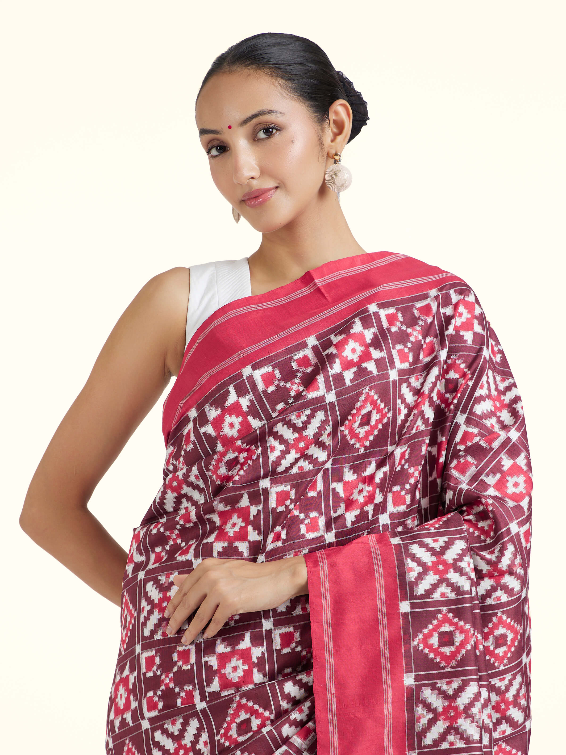 Angled view of red mulberry silk Ikat saree emphasizing handcrafted Ikat weave and sheen