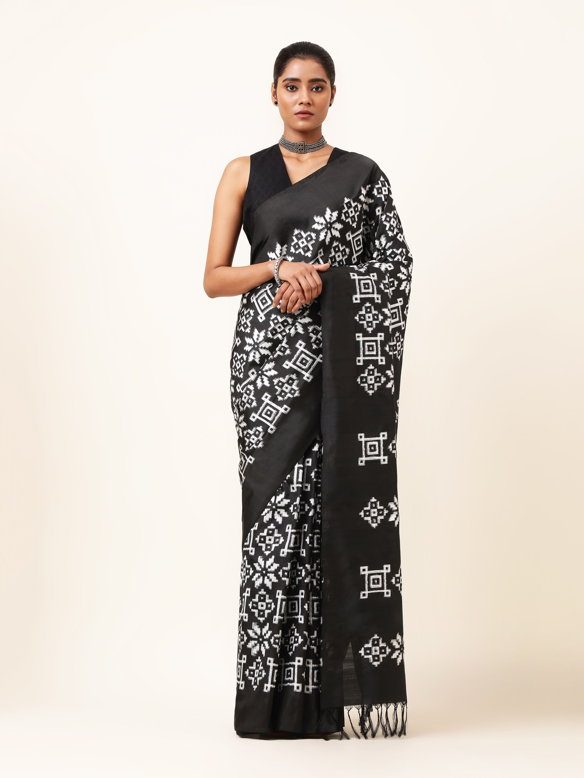 Front view displaying the striking black silk saree with traditional double ikat patterns.
