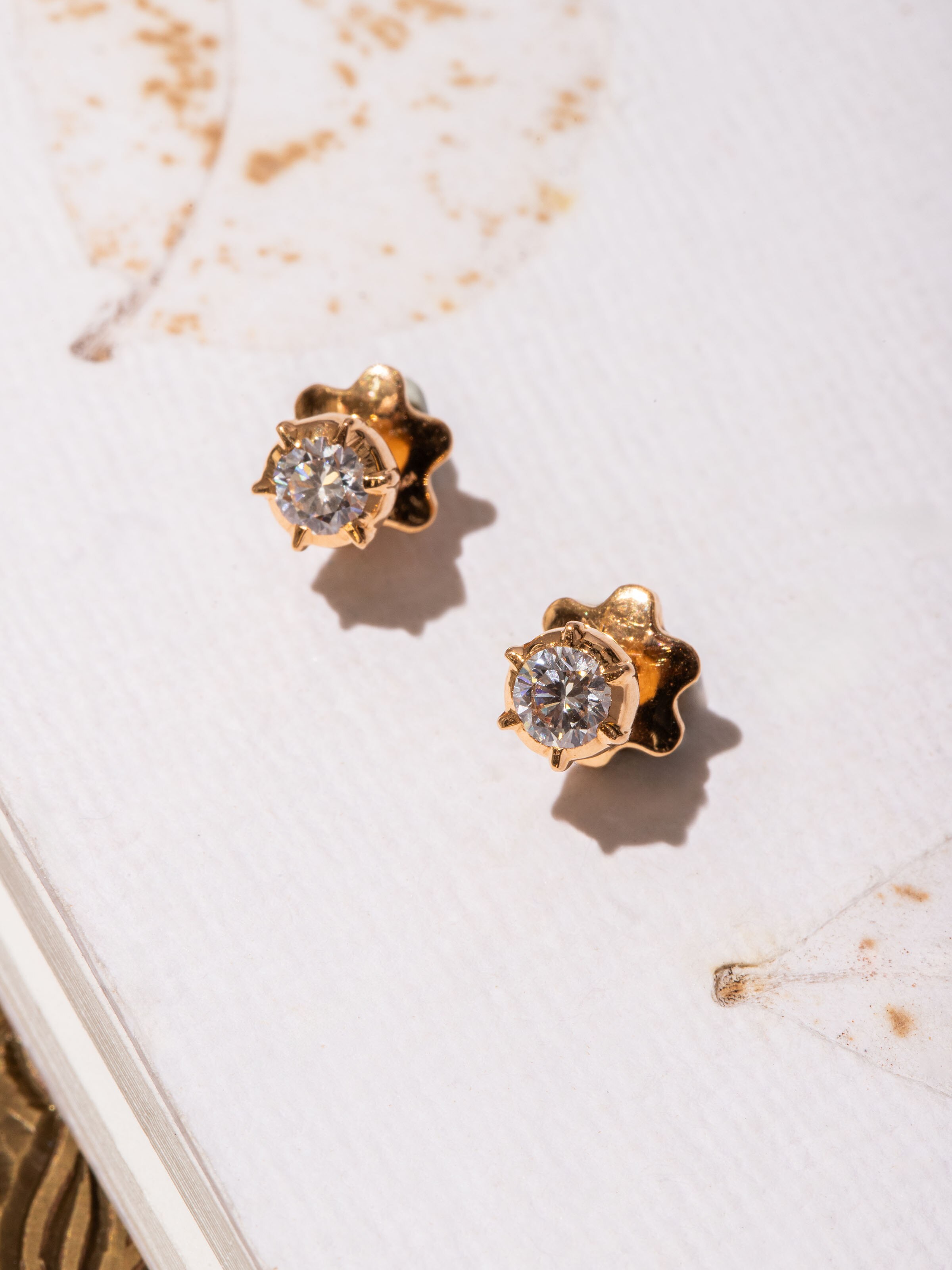 Alternate side view of close-setting 22 karat gold studs displaying compact form and radiant shine