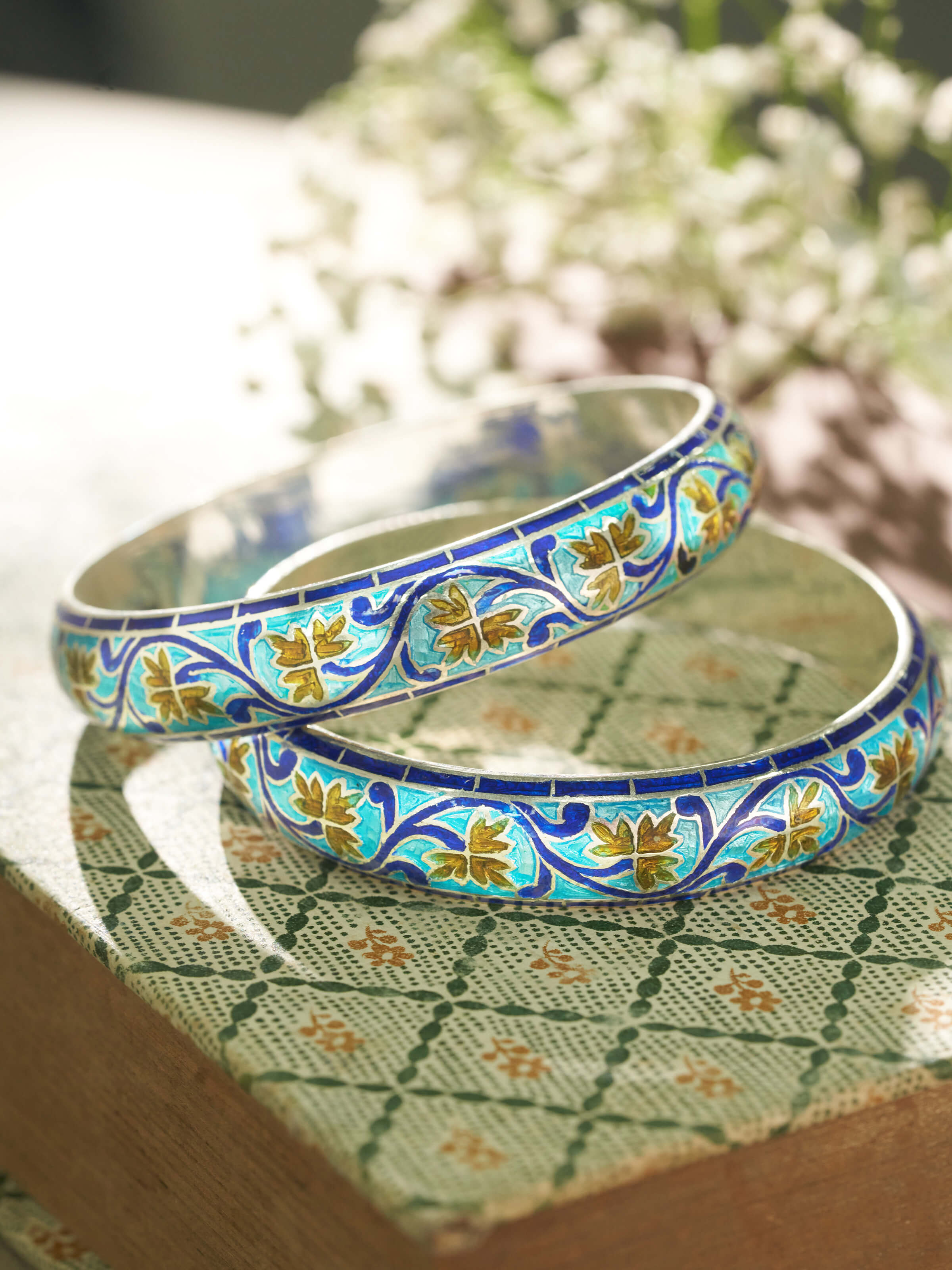 Overhead view of blue meenakari silver bangles showing their full design and vibrant colors.