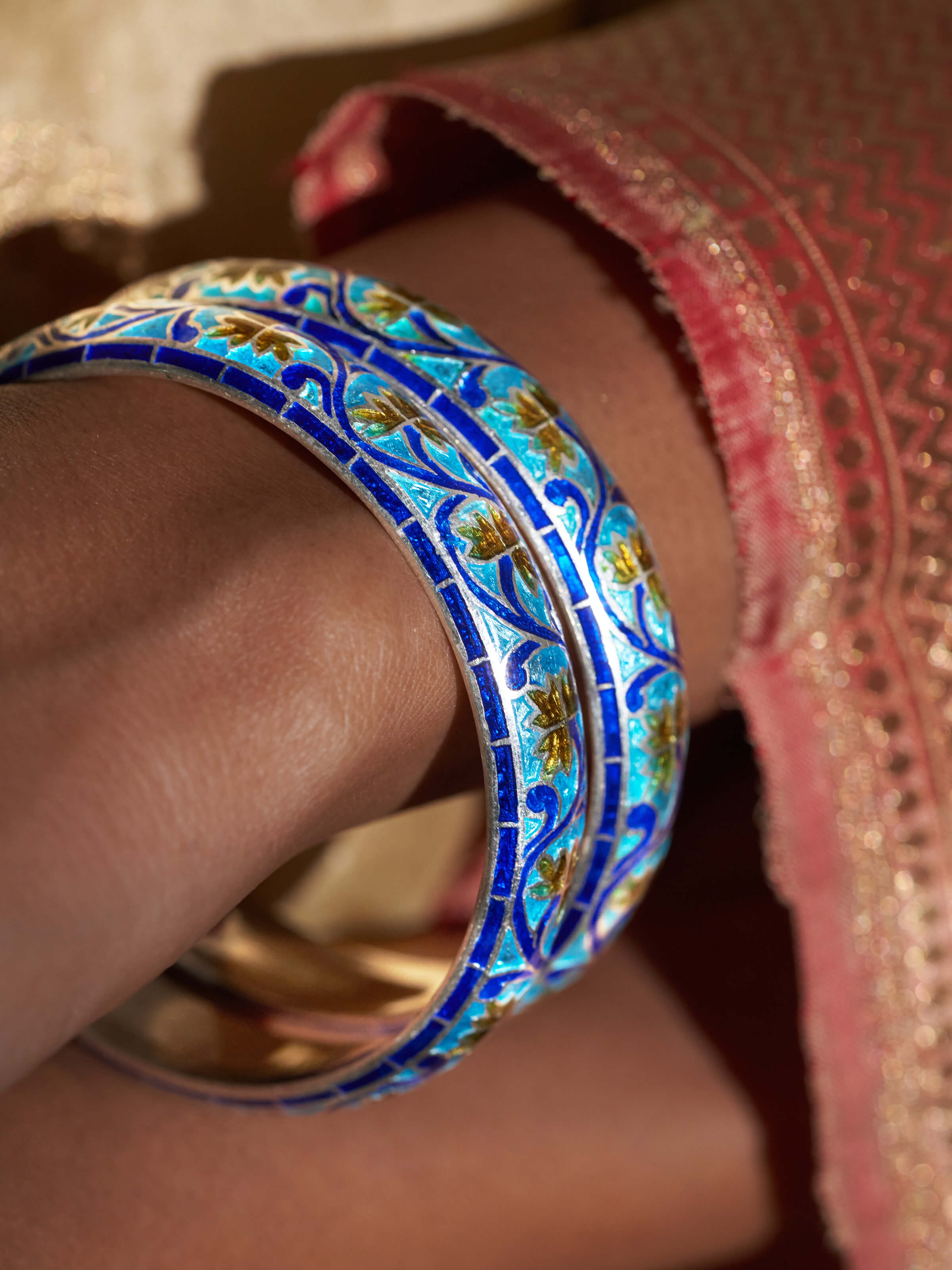 Close-up of blue meenakari silver bangles revealing detailed enamel work and traditional patterns.