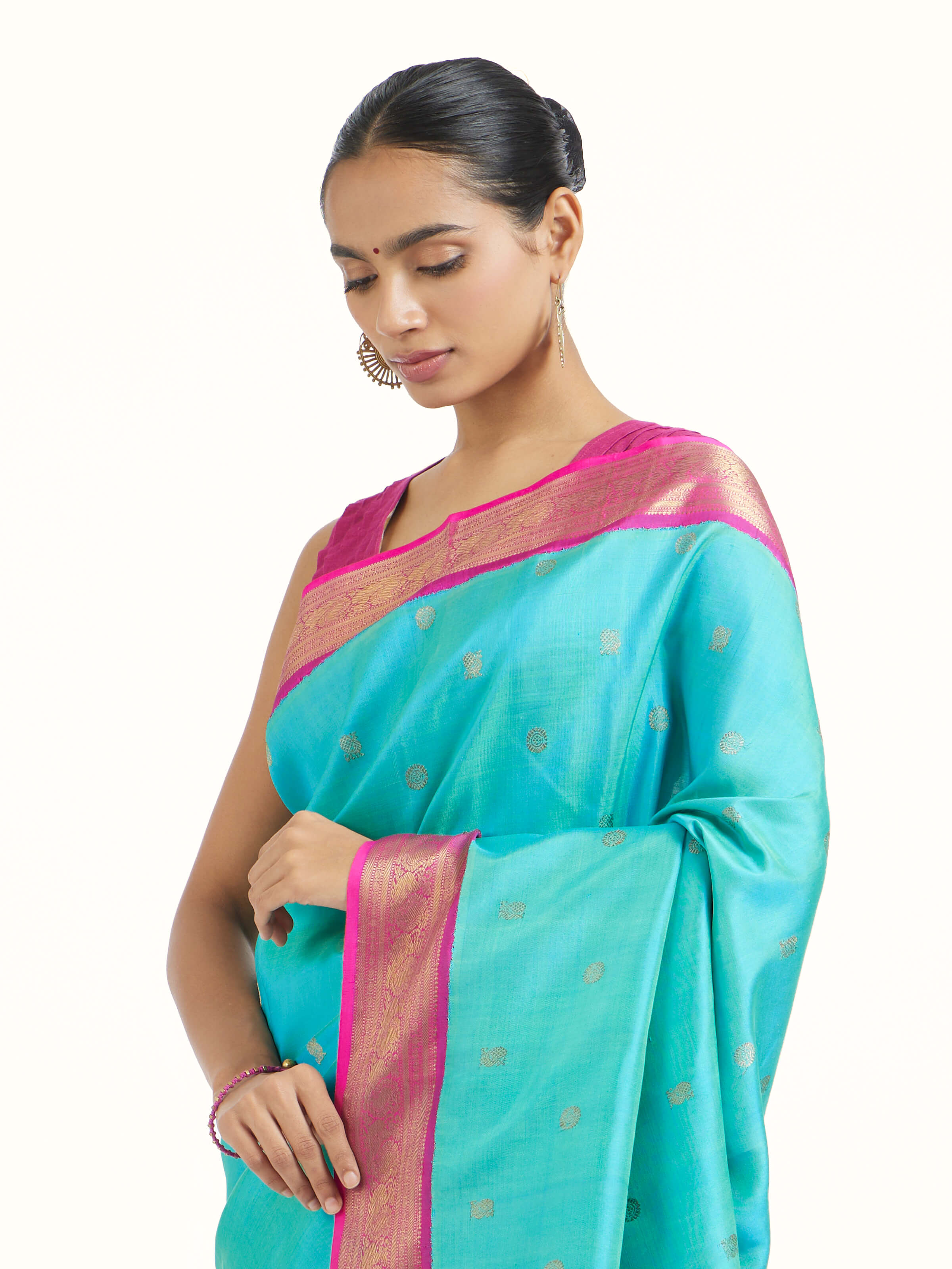 Angled view of turquoise silk Kancheepuram saree emphasizing traditional Kancheepuram weave
