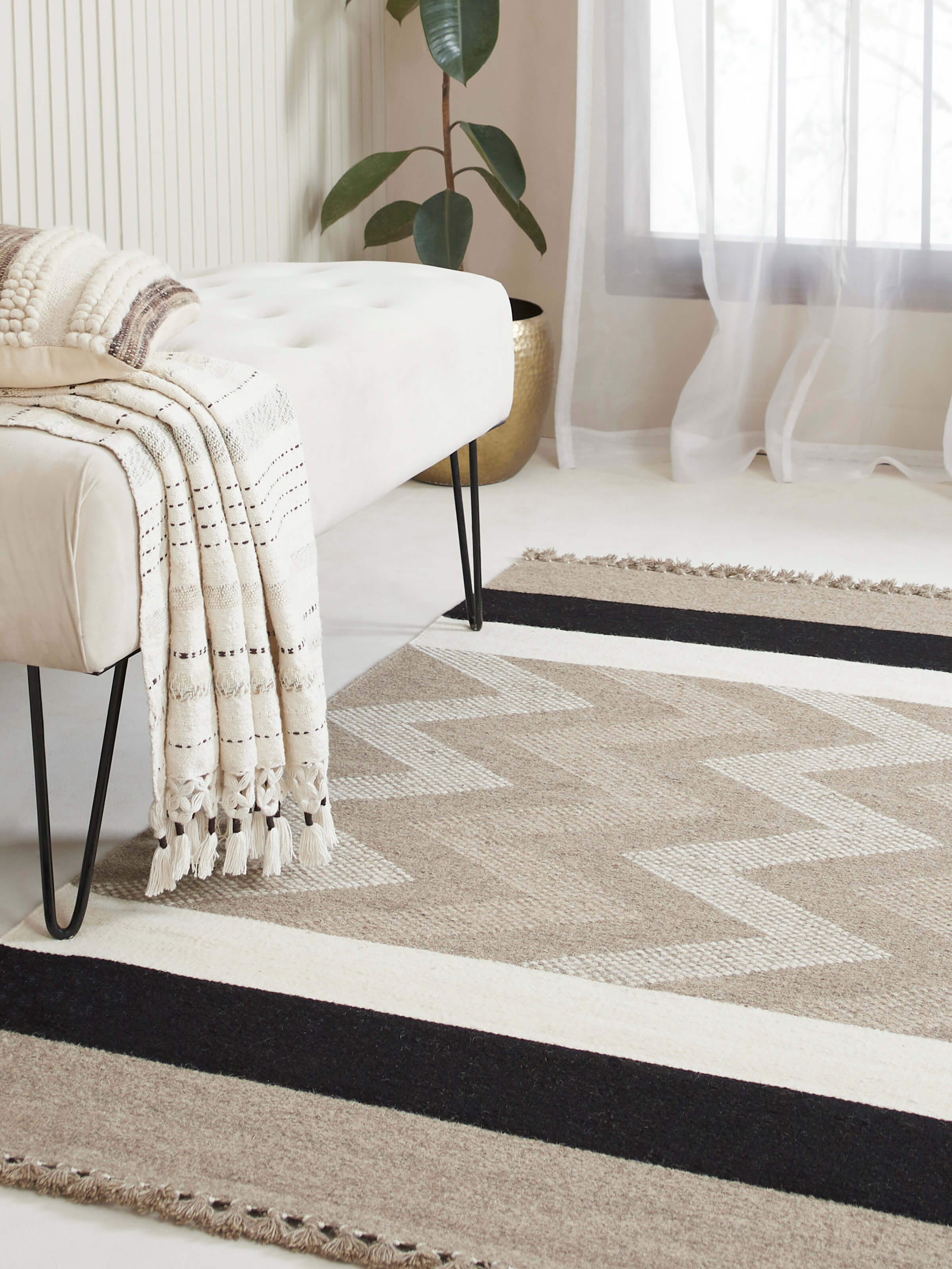 Lifestyle room view showcasing beige melange wool dhurrie with chevron handloom texture.