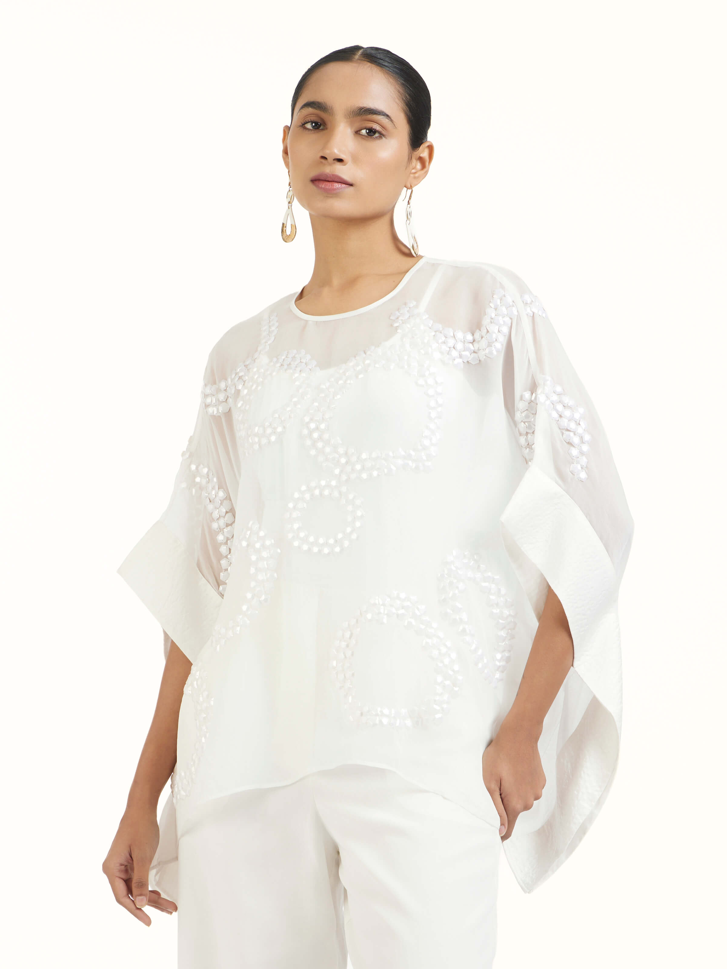 Angled view of ivory hand embroidered organza kaftan emphasizing intricate embroidery and sheer texture