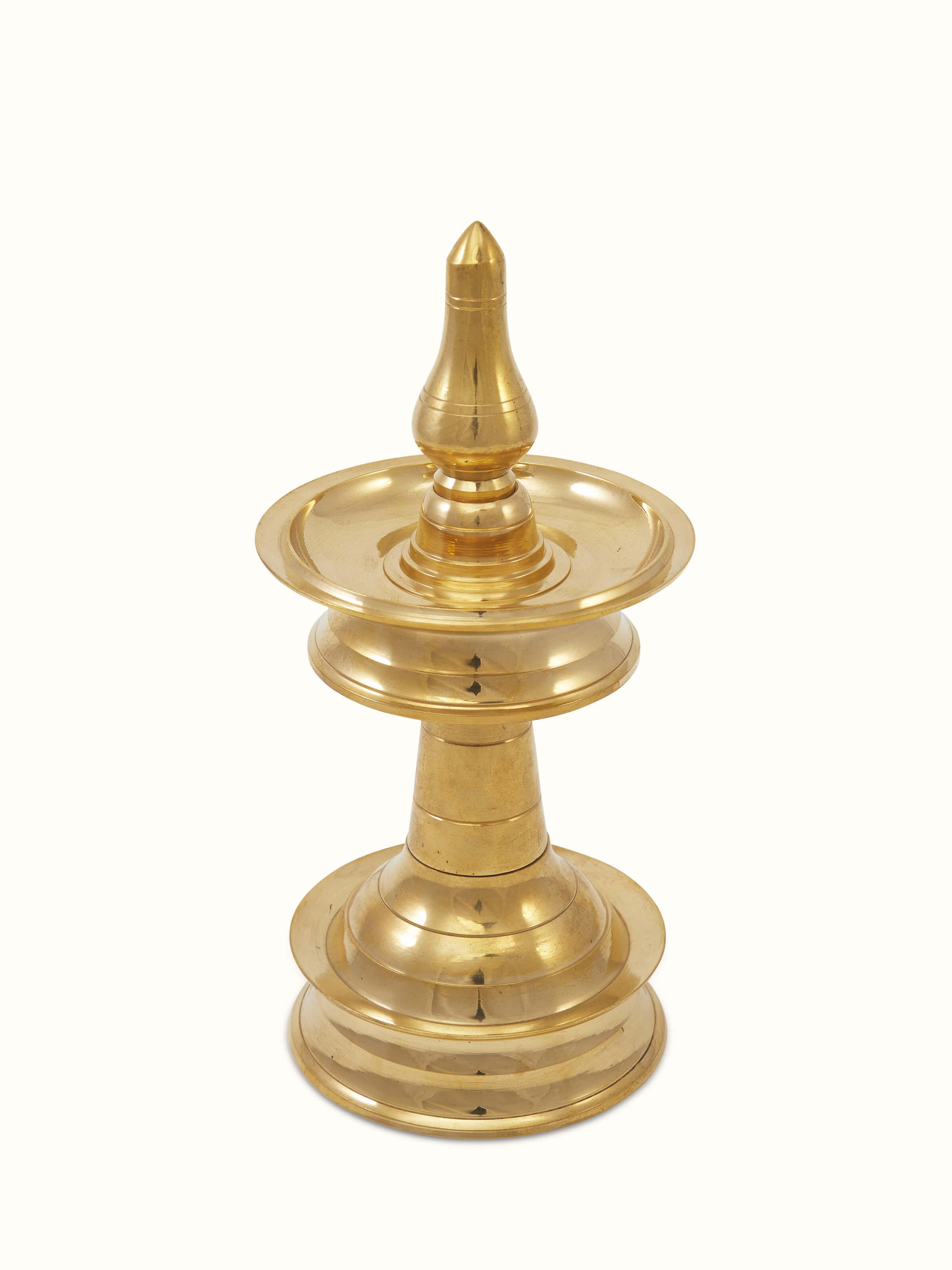 Close-up view of traditional brass samai vilakku stand diya emphasizing ornate design and traditional style