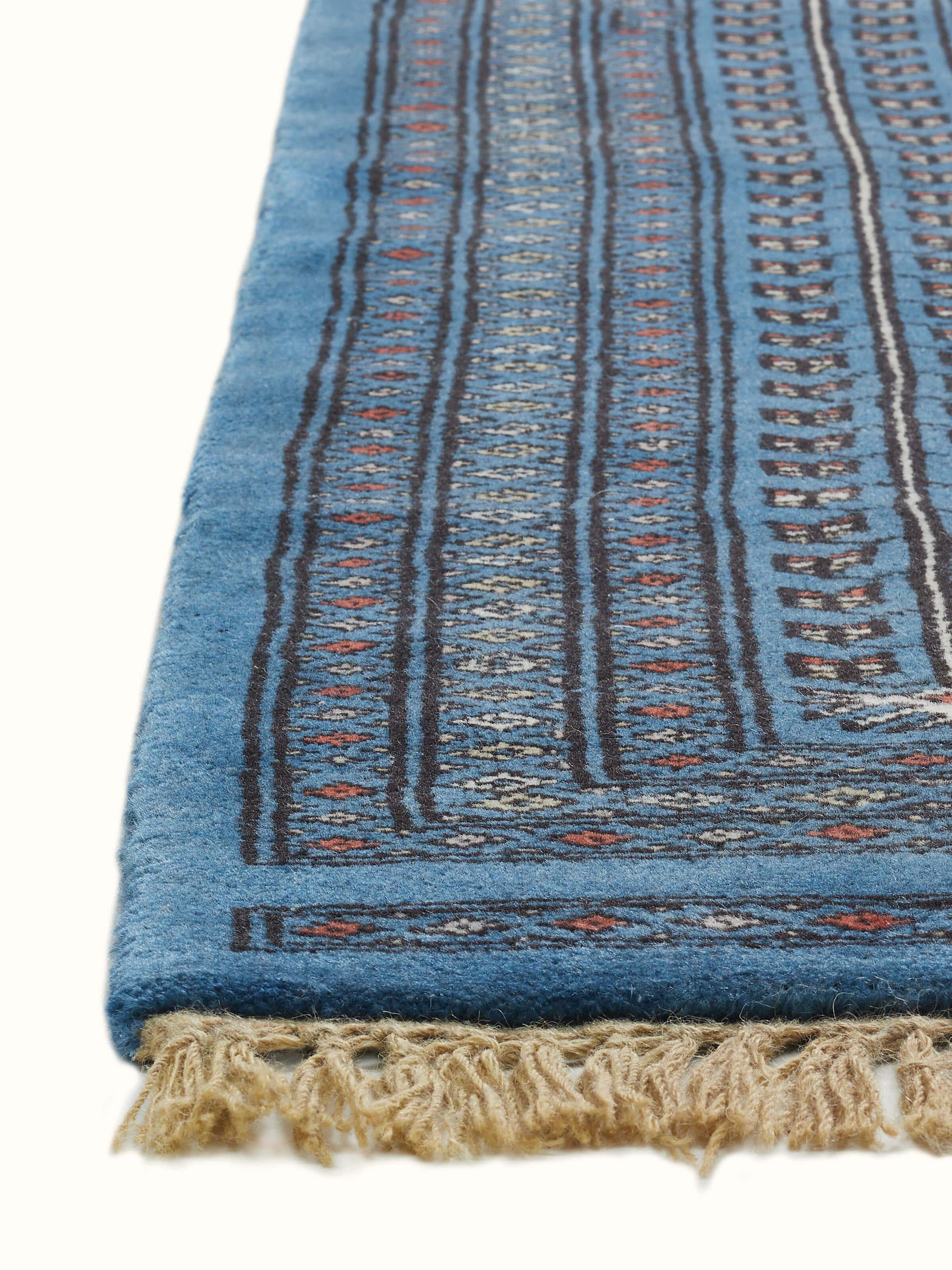 Angle view of Amritsari Parda Blue Hand-knotted Wool Rug from Gwalior, with fine floral pattern work by Swadesh