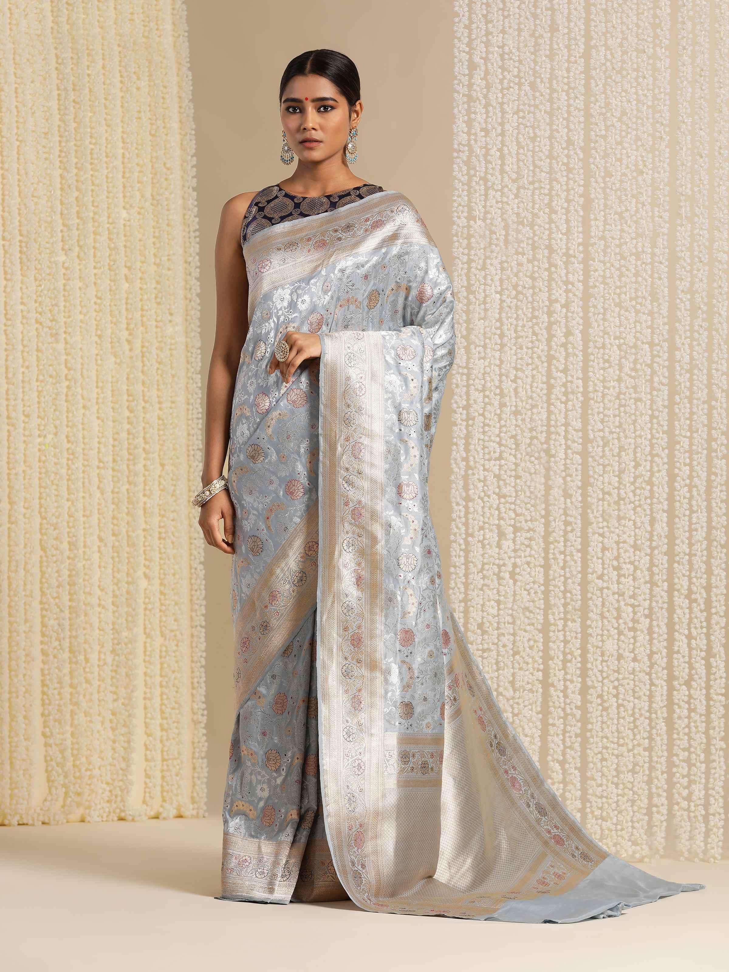 Angled lifestyle view of ice blue Katan silk saree highlighting soft luster and drape.