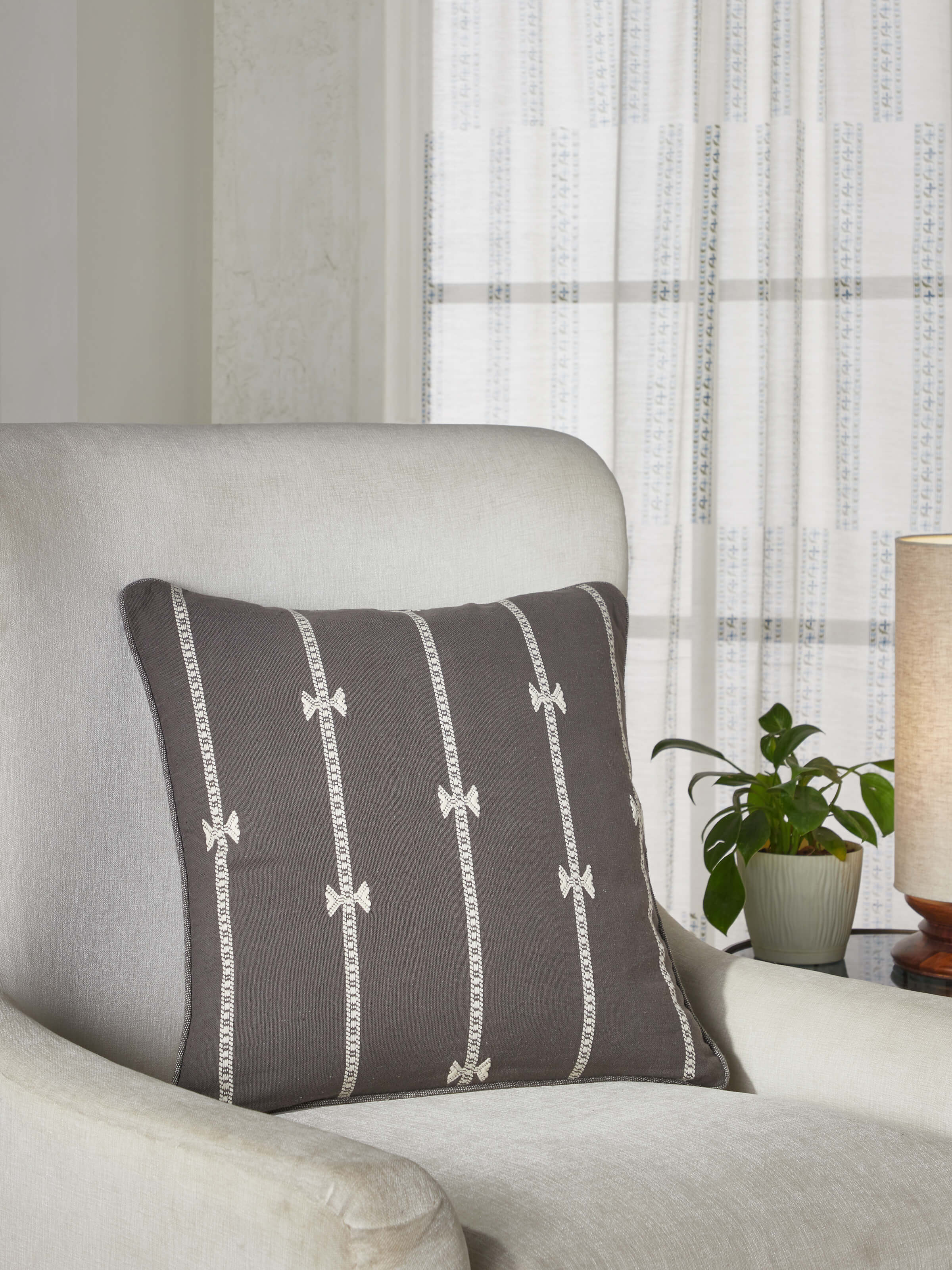 Lifestyle image featuring Anek Coffee Bhujodi Cushion Cover styled on a sofa in a modern living space