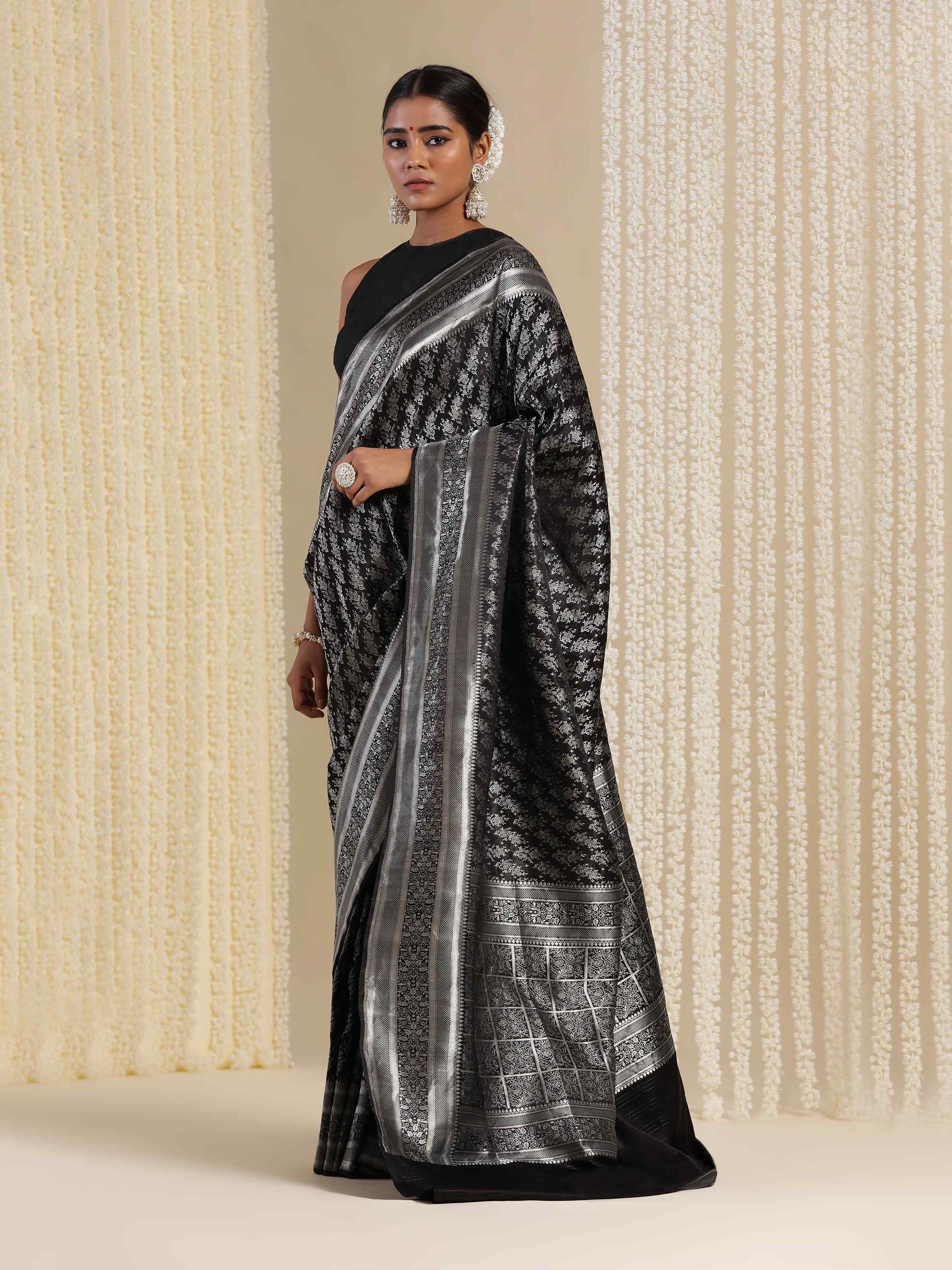 Angled close-up of Black Silk Satin Tanchoi Banarasi Saree showing detailed weave and pattern.