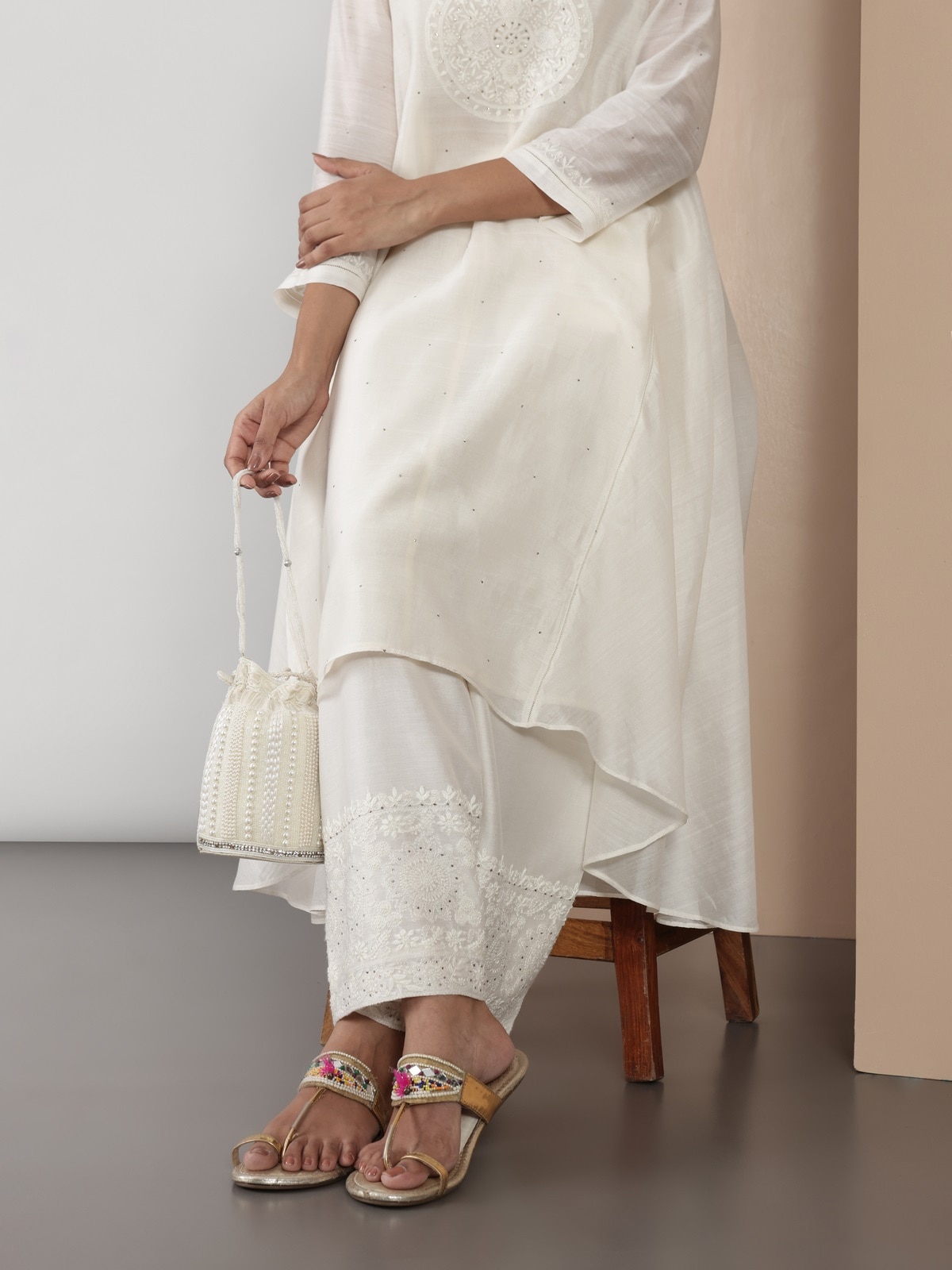 Lifestyle view showing side profile of off-white Chikankari palazzo highlighting flowing cotton silk fabric