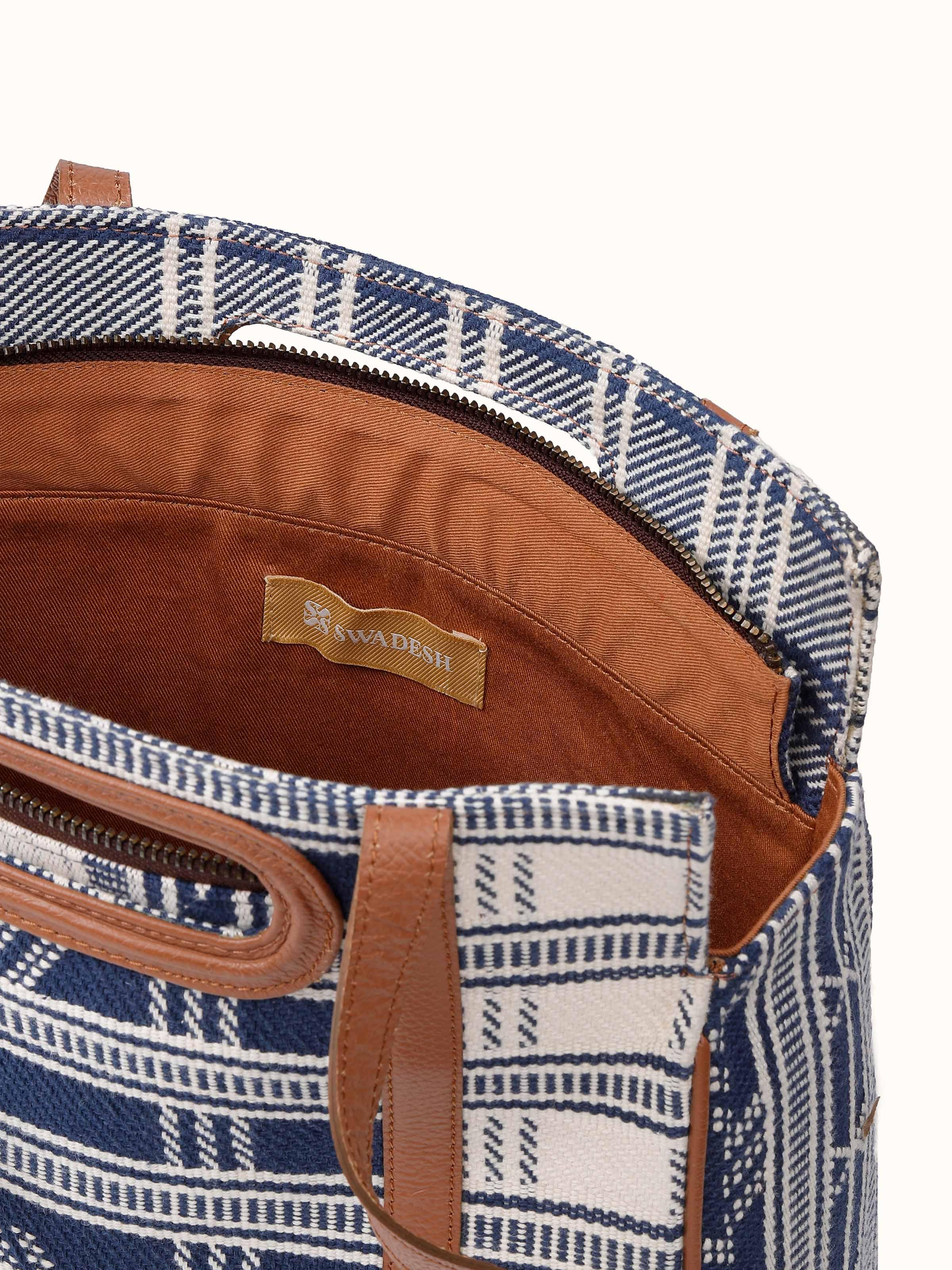 Close-up of leather-textile sling bag showing extra-weft weave and stitch finish.