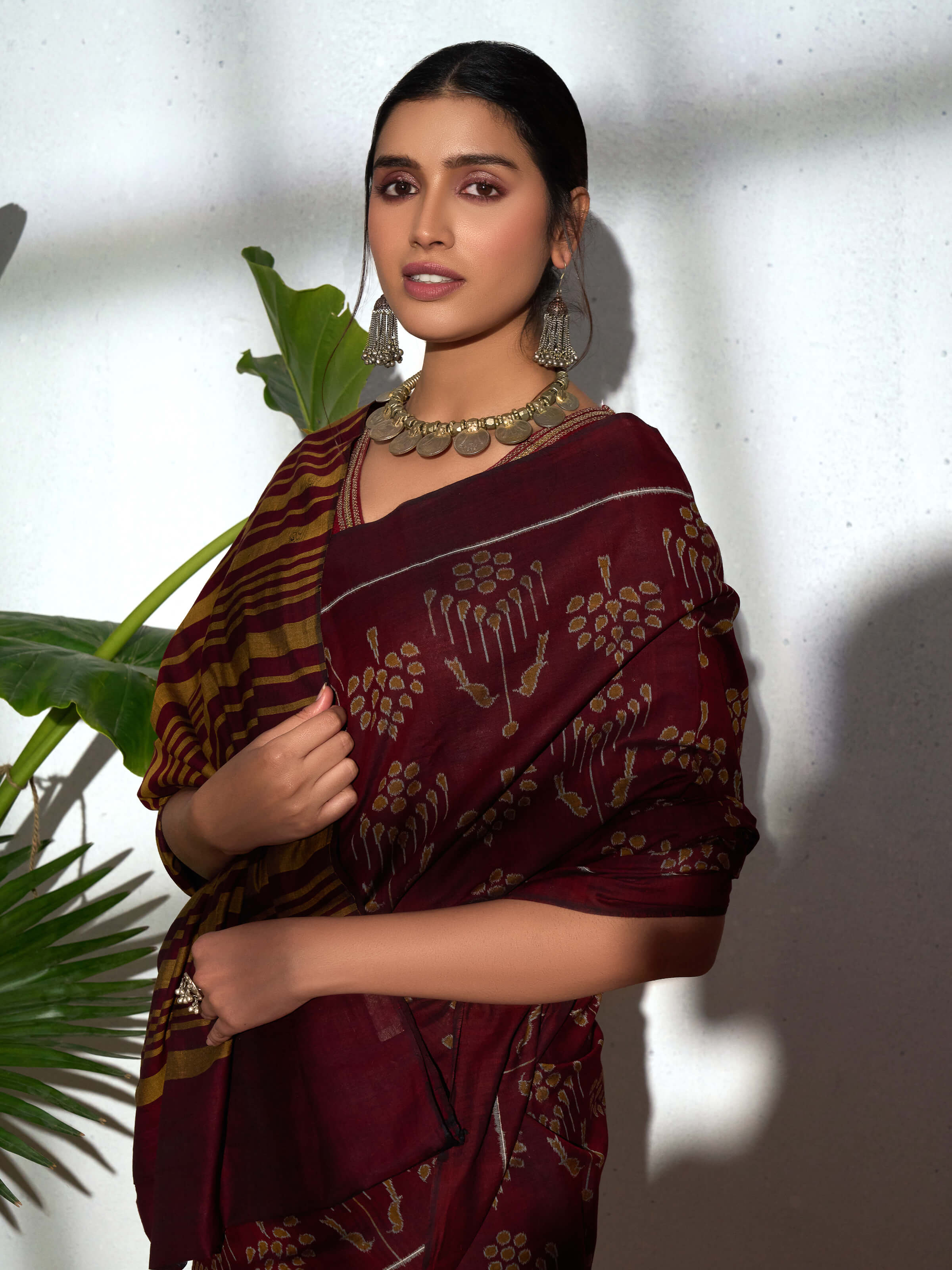 Angled view of brown cotton Odisha ikat bandha saree highlighting resist-dyed weave and texture