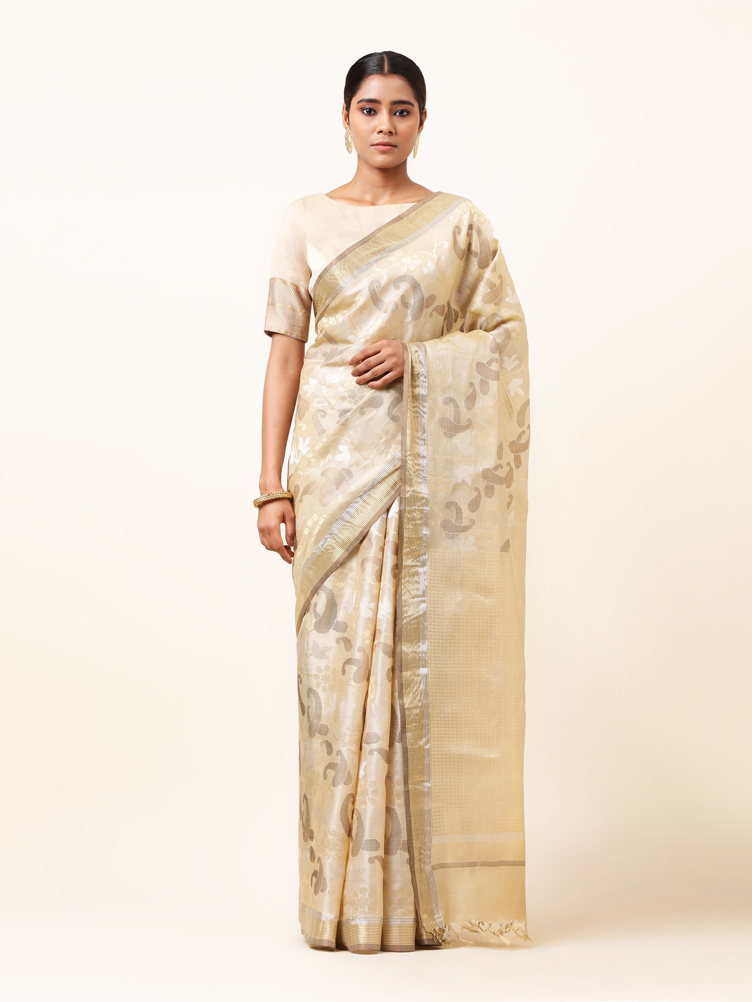 Front view of beige tussar silk saree showcasing fine texture and traditional weave