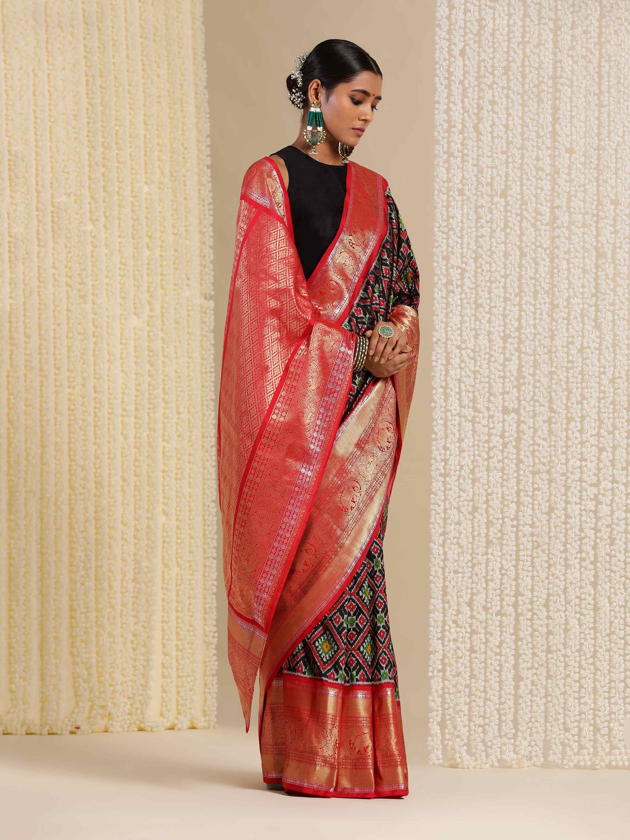 Wide lifestyle shot of blue Ikat saree showing pallu drape and fluidity.