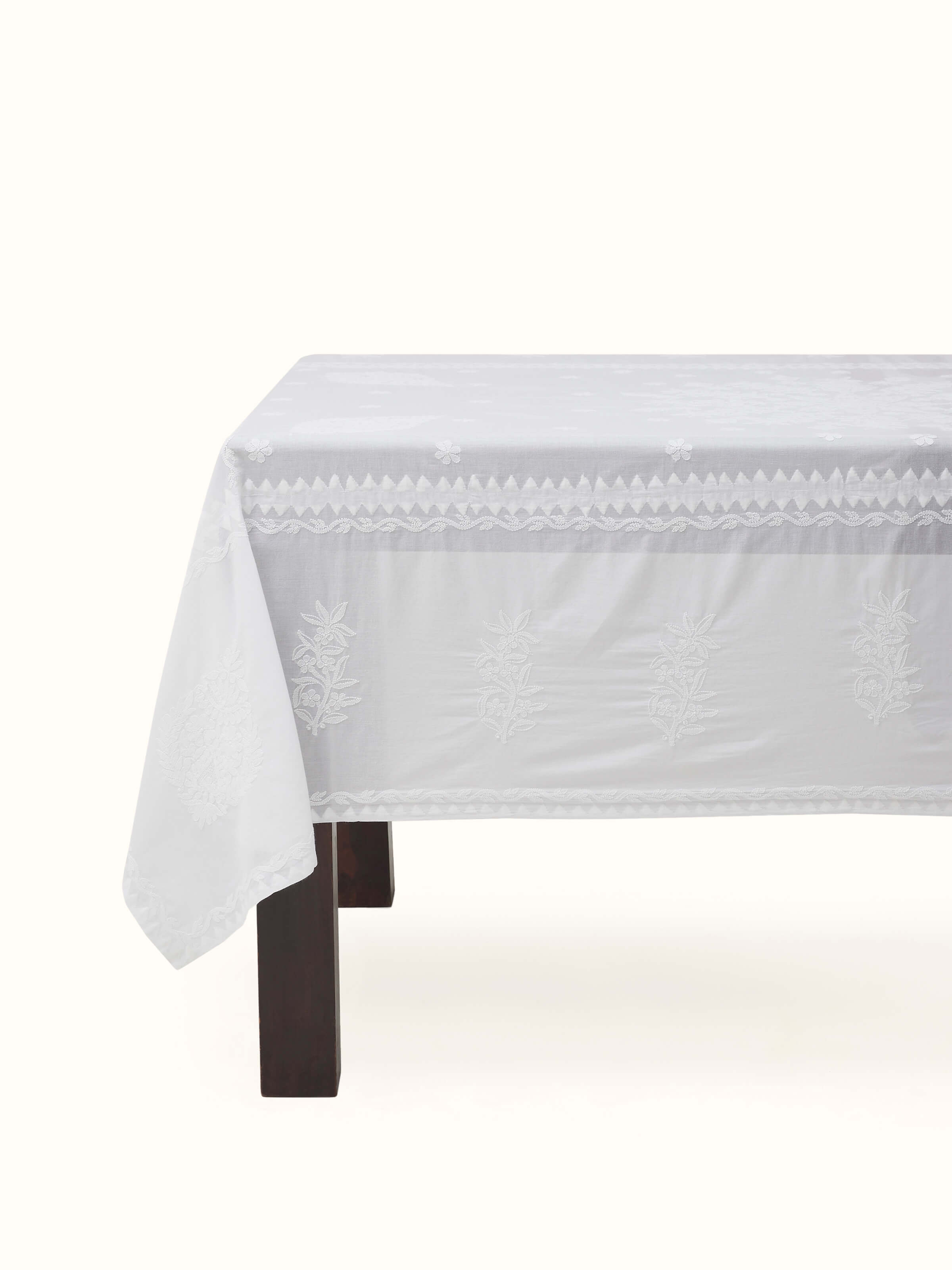 Front view of Ananda white cotton table cover with medallion buta Chikankari embroidery laid out for 4-seater.