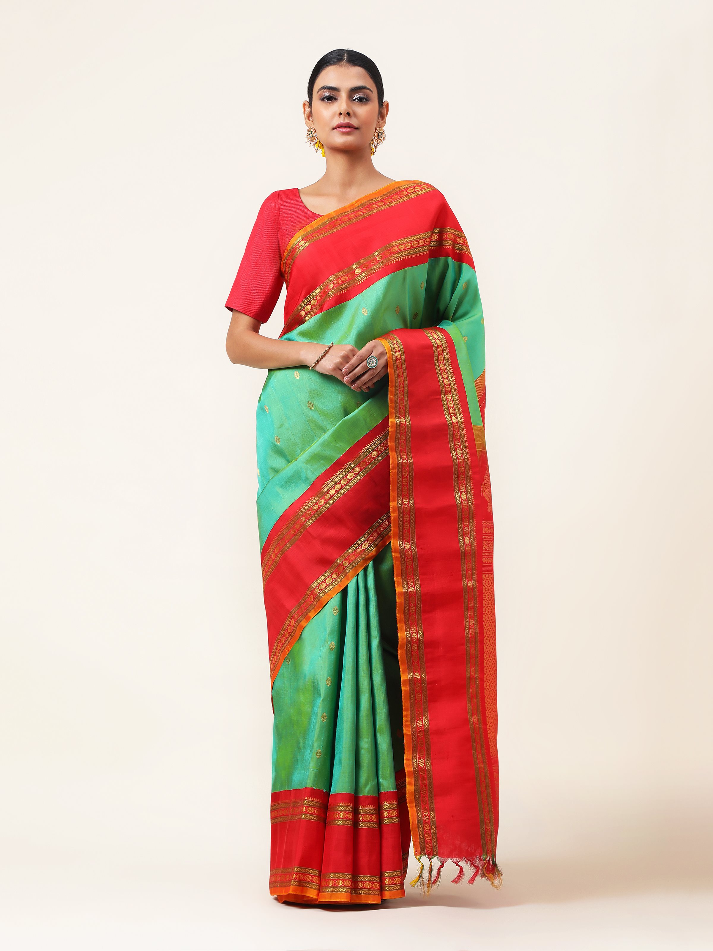 Front view of green silk Gadwal saree with contrasting border and woven pallu.