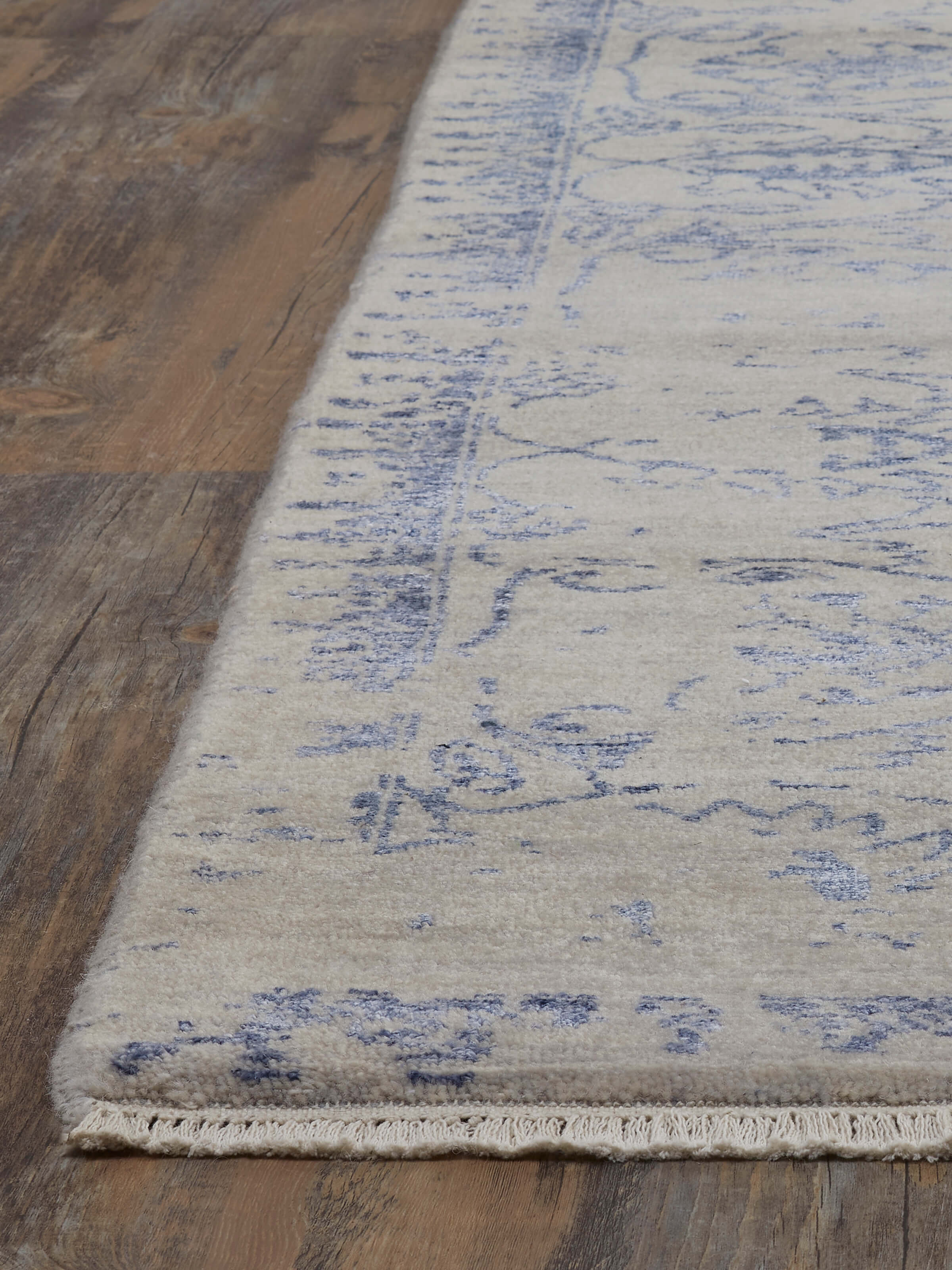 Angled view of Distressed Transitional Grey Blue Agra wool & viscose hand-knotted rug emphasizing the color variations