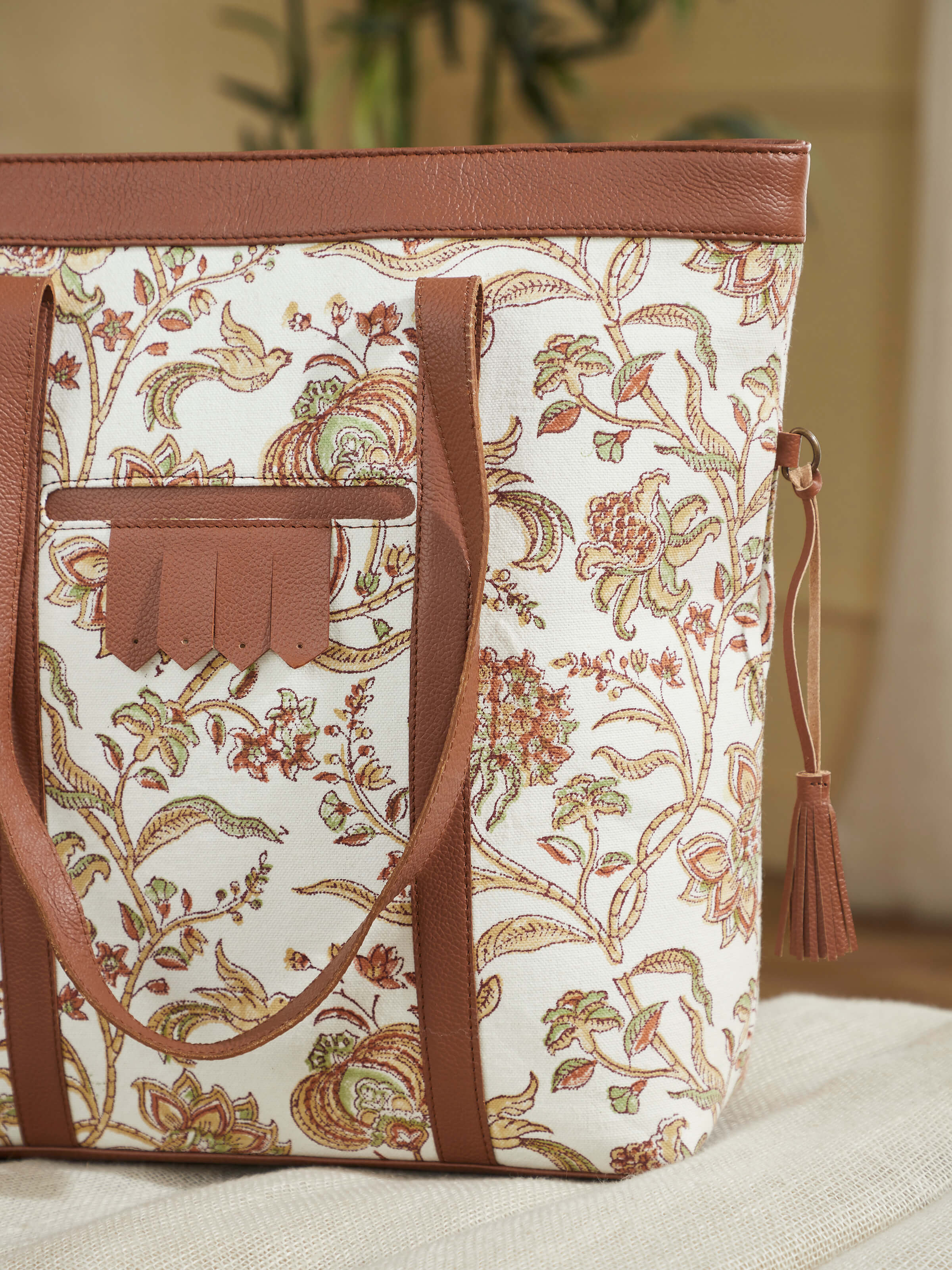 Angled view of mustard leather and textile hand block printed tote bag showing side profile.