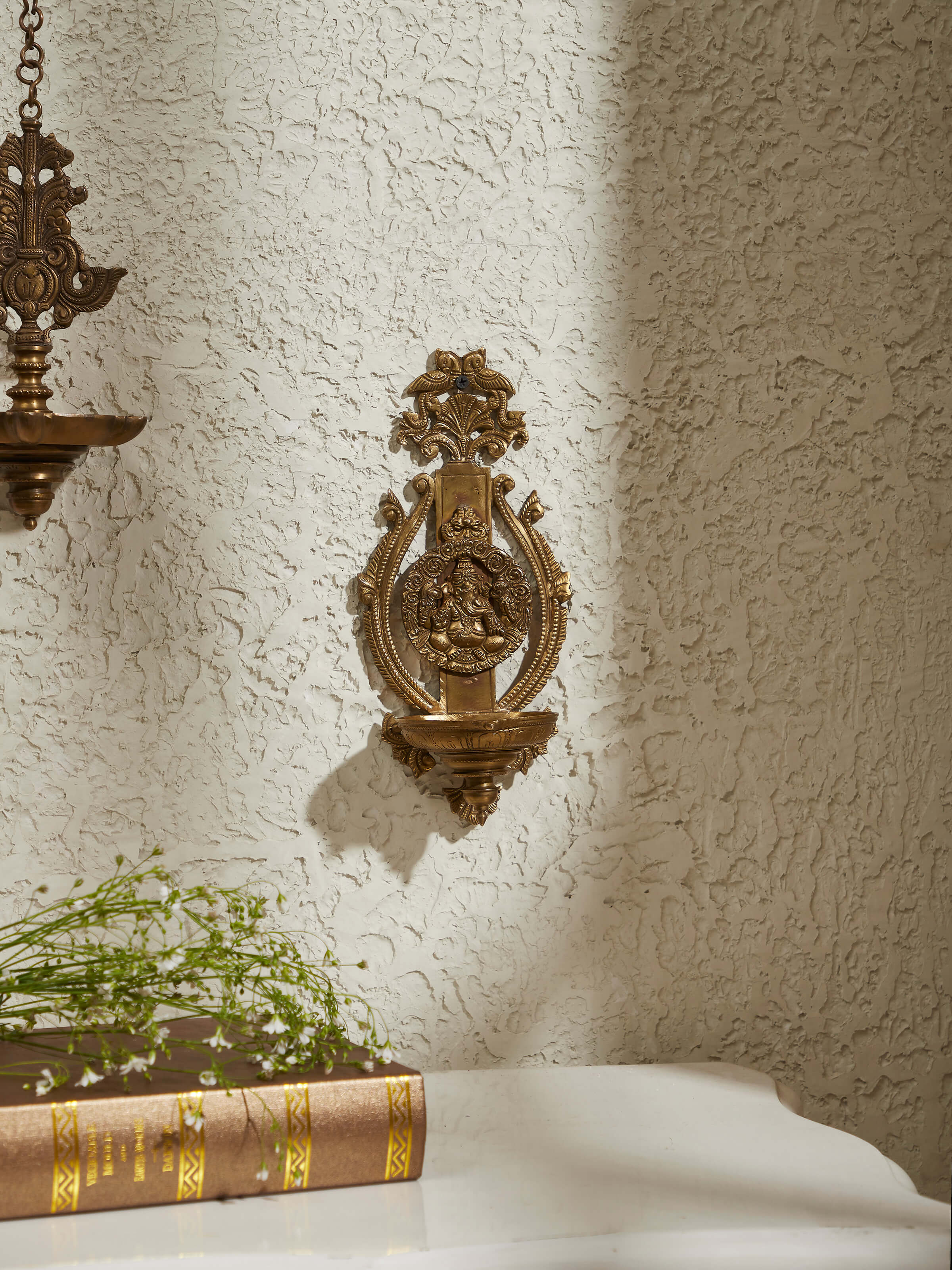 Close-up view of polished casting hanging diya, showcasing its detailed craftsmanship and shine.