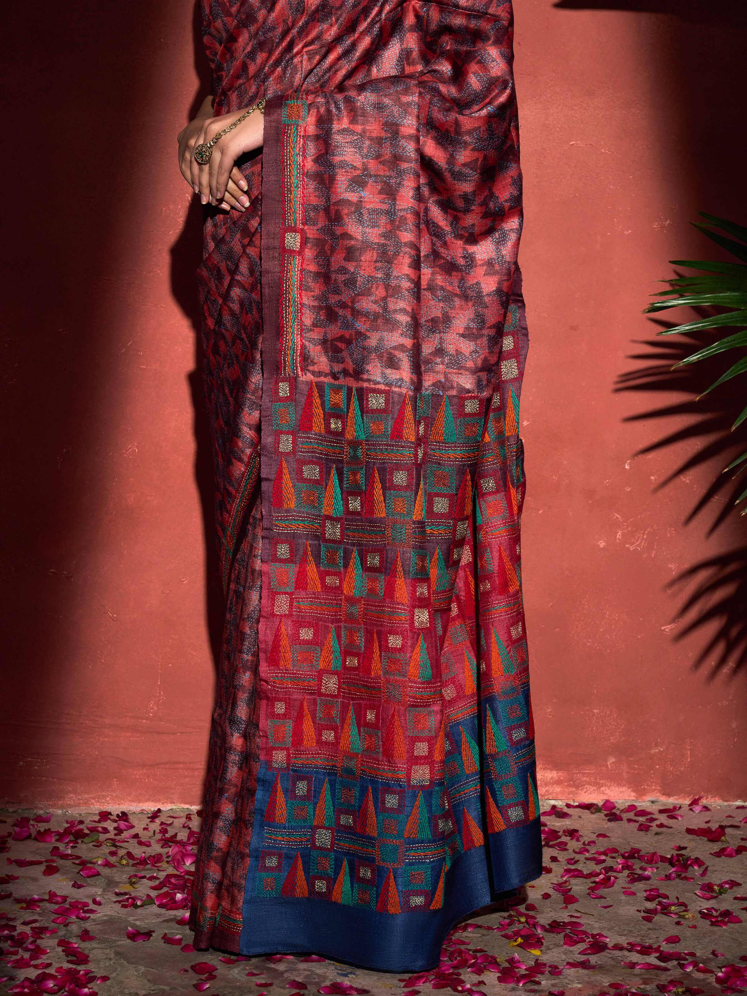 Detail view of red tussar silk discharge printed Kantha embroidered saree showing embroidery