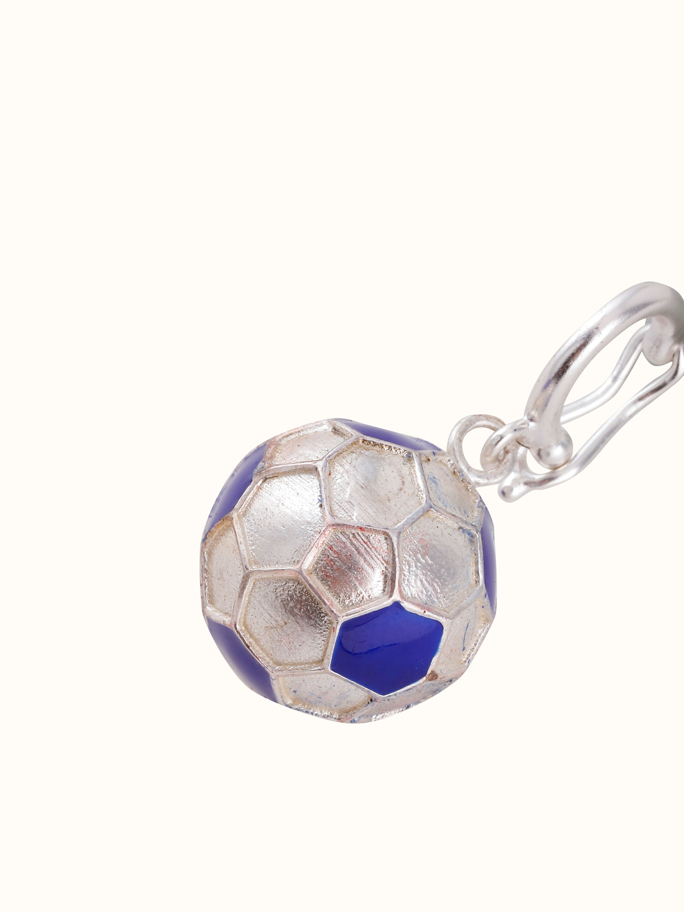 Overhead view of silver pendant displayed against neutral backdrop to emphasize craftsmanship.