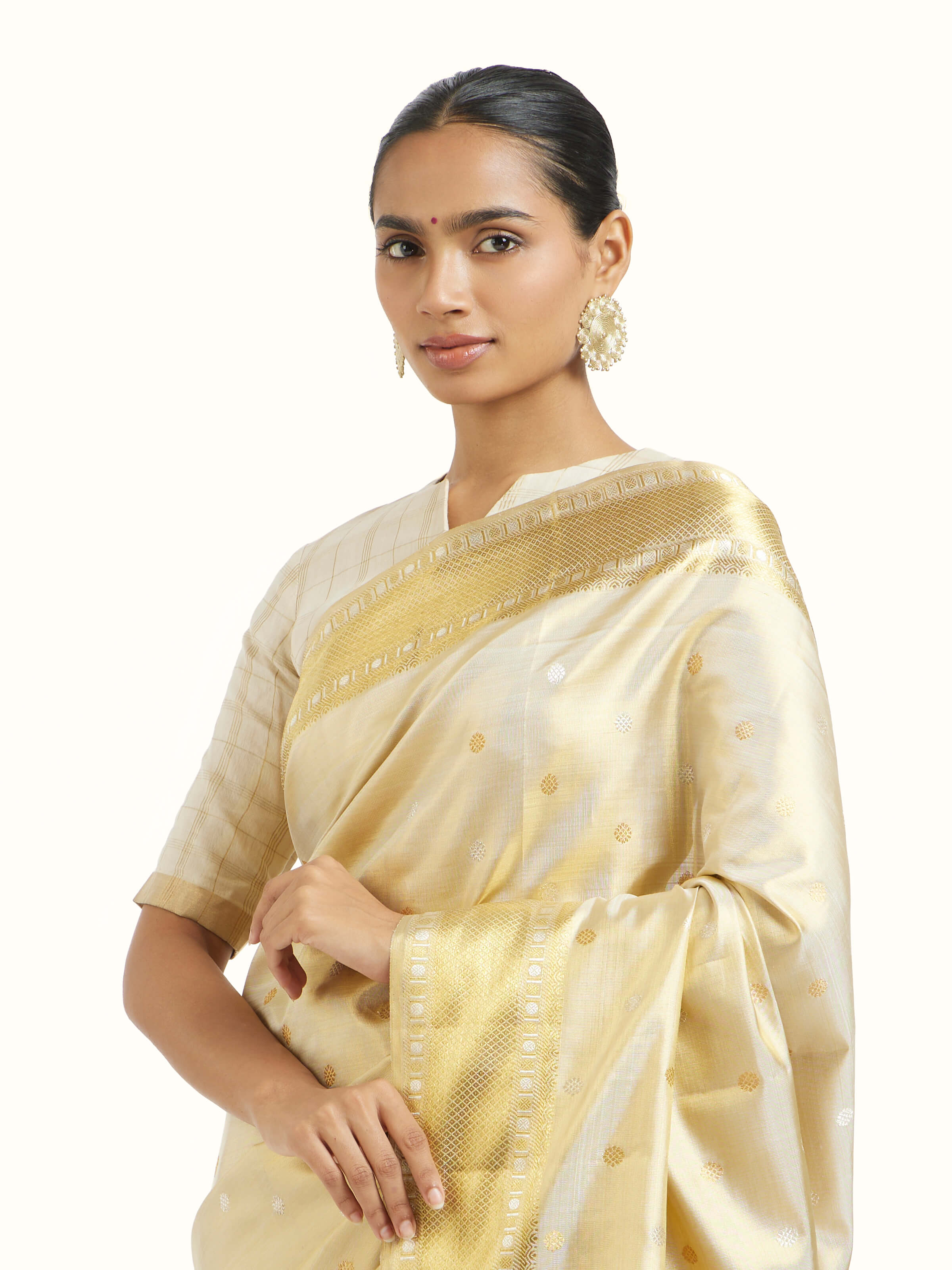 Angled view of beige silk Kancheepuram saree showcasing traditional weave and sheen
