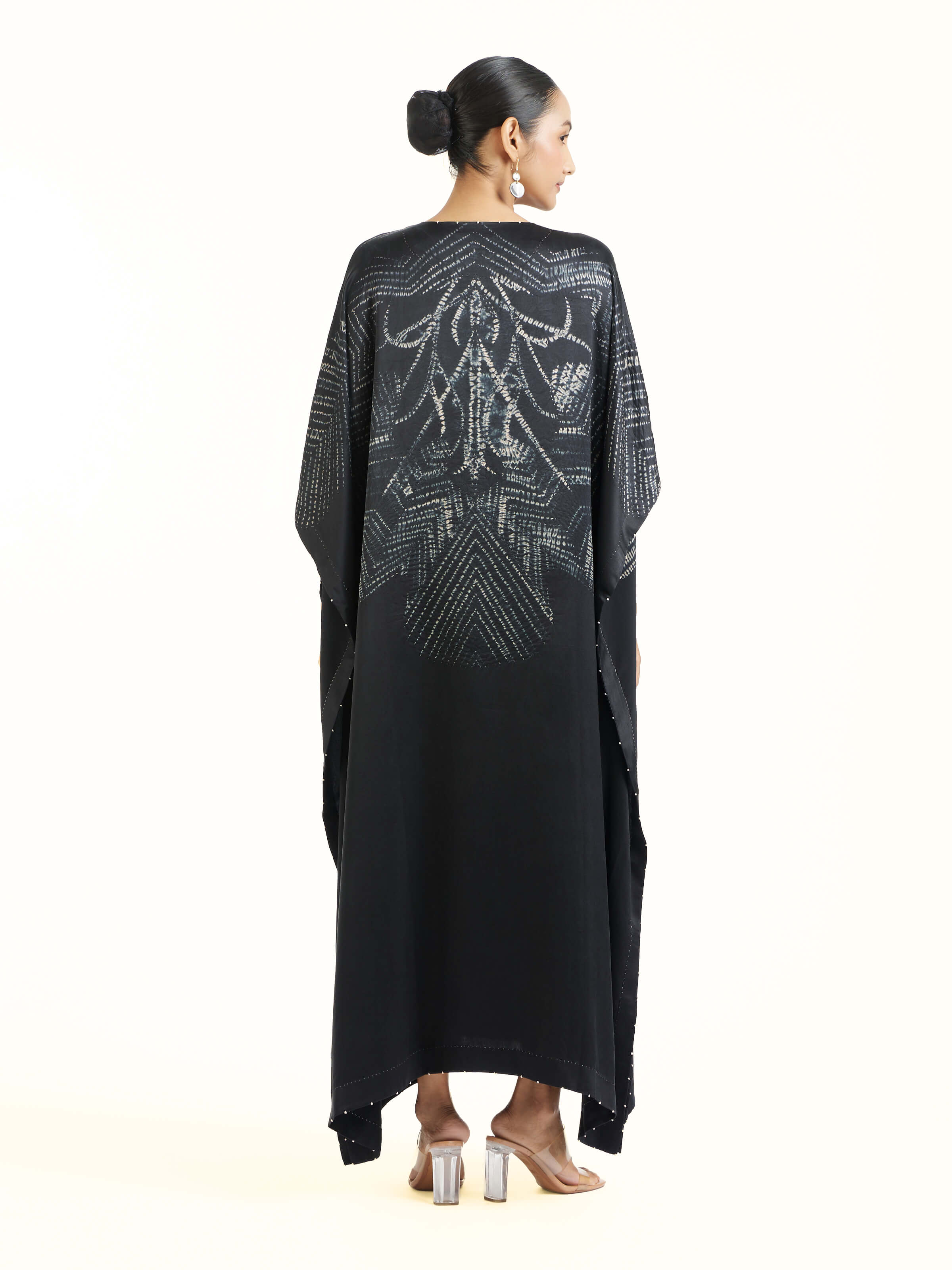 Back view of black satin shibori kaftan displaying flowy fit