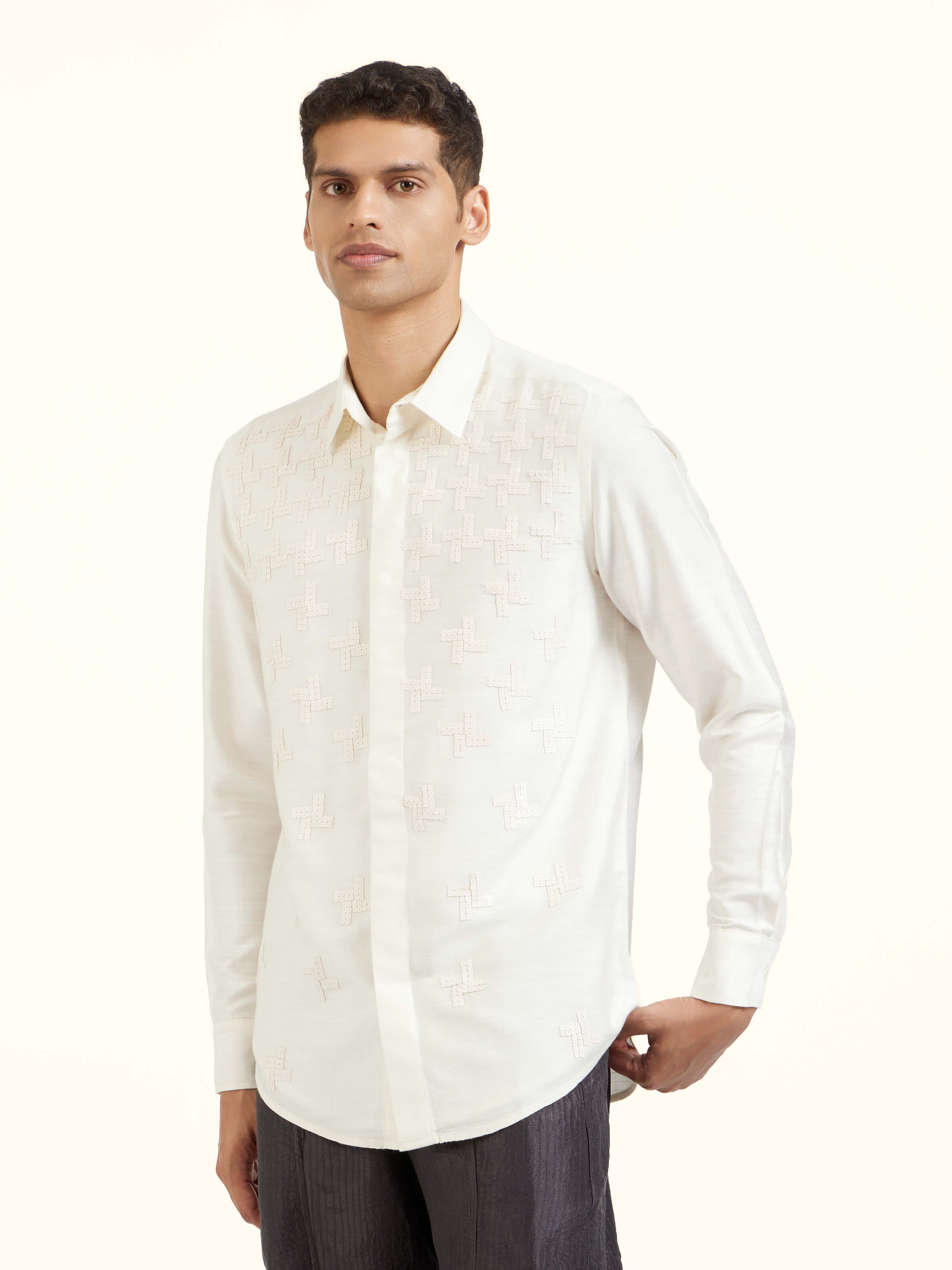 Angled view of white hand embroidery shirt highlighting embroidery craftsmanship and fabric texture