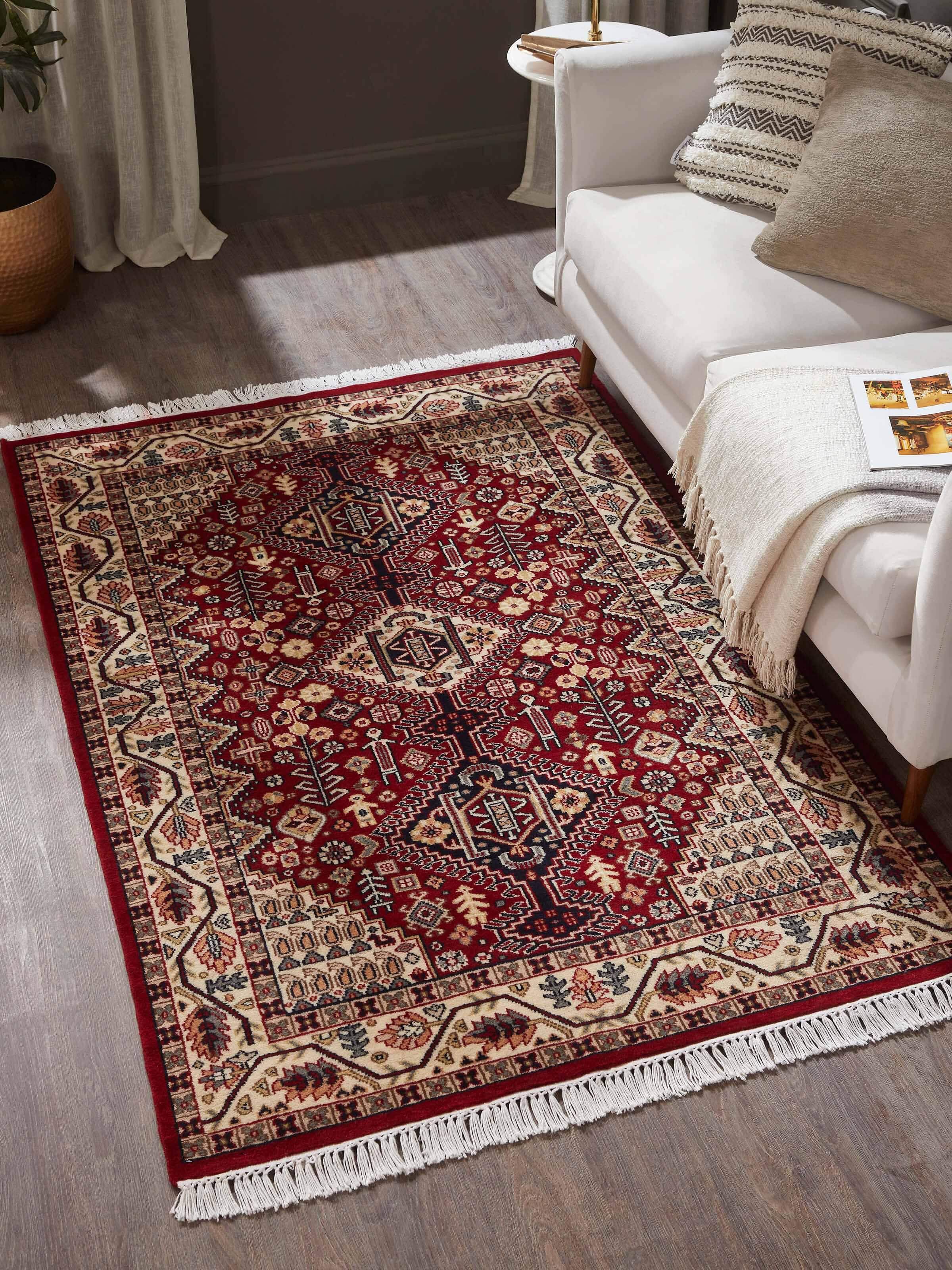 Room setting featuring rust Persian Kazak carpet with traditional geometric patterns