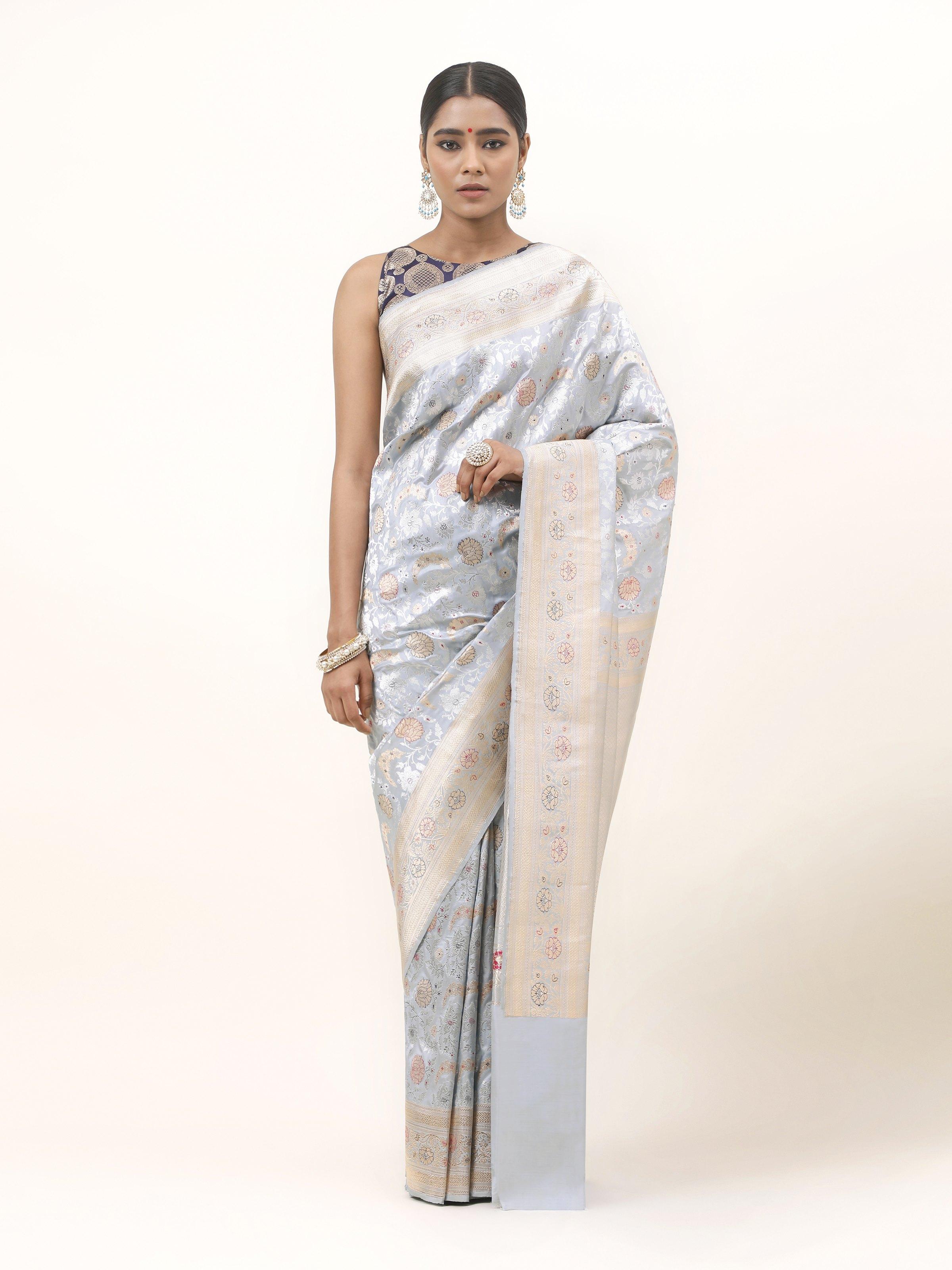 Front view of ice blue Katan silk Banarasi saree with gold zari floral patterns and classic border.