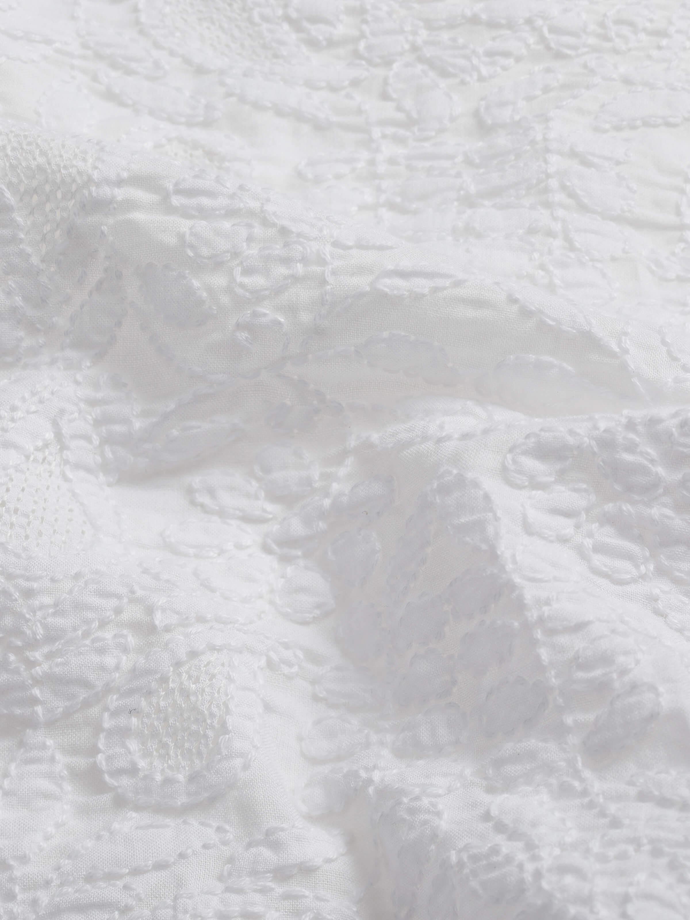 Close-up focusing on the fine craftsmanship and detailed hand embroidery stitches