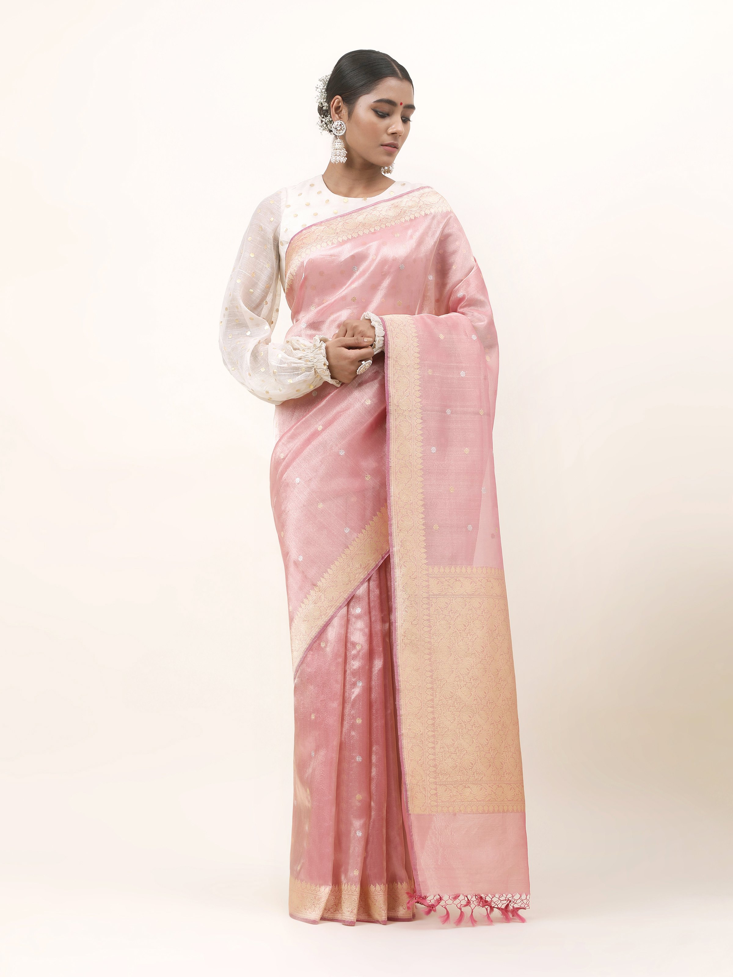 Front view of pink tissue silk Banarasi saree with intricate golden zari motifs.
