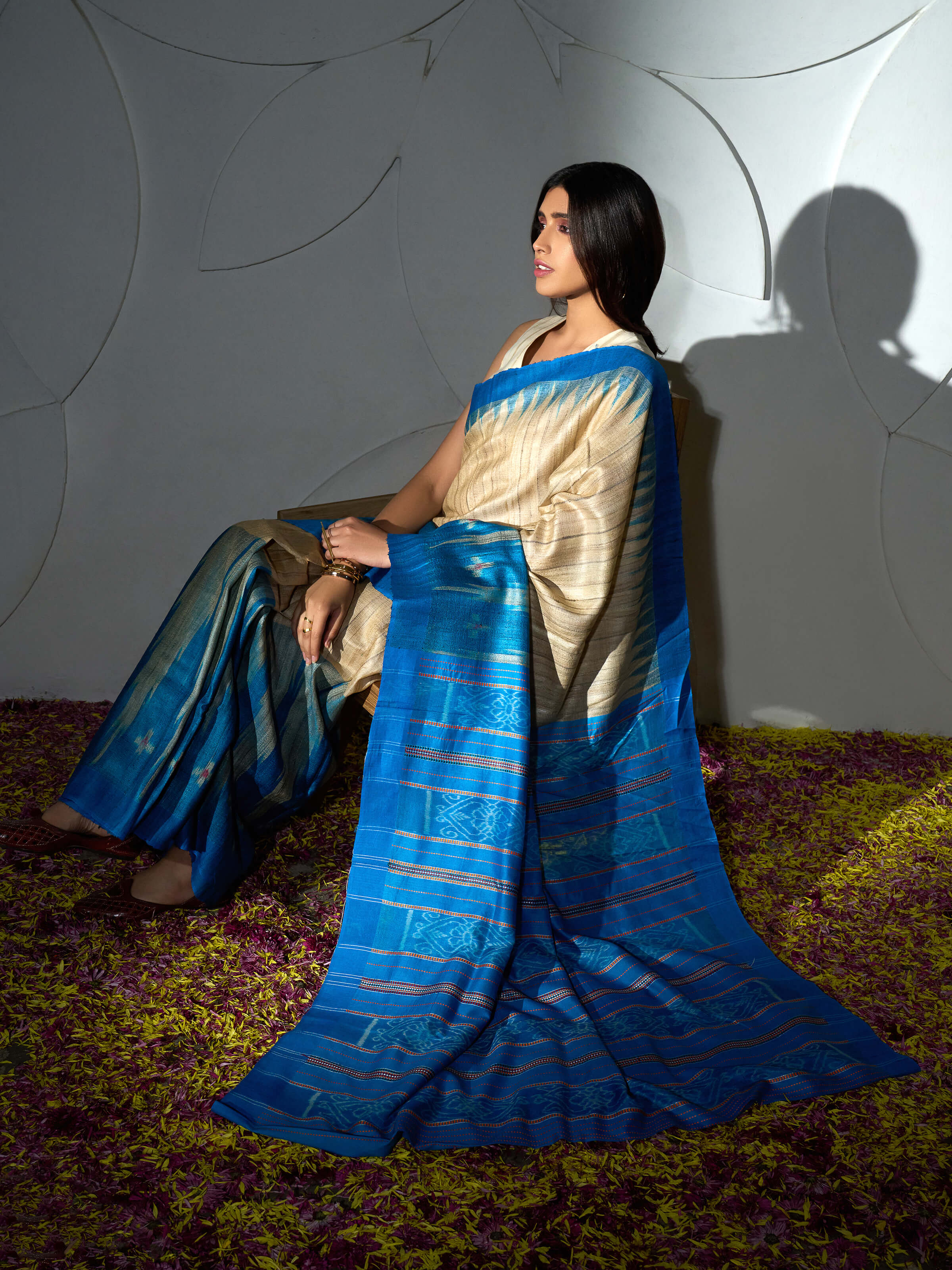 Angled view of turquoise tussar ghicha silk Bandha ikat saree highlighting pallu and border
