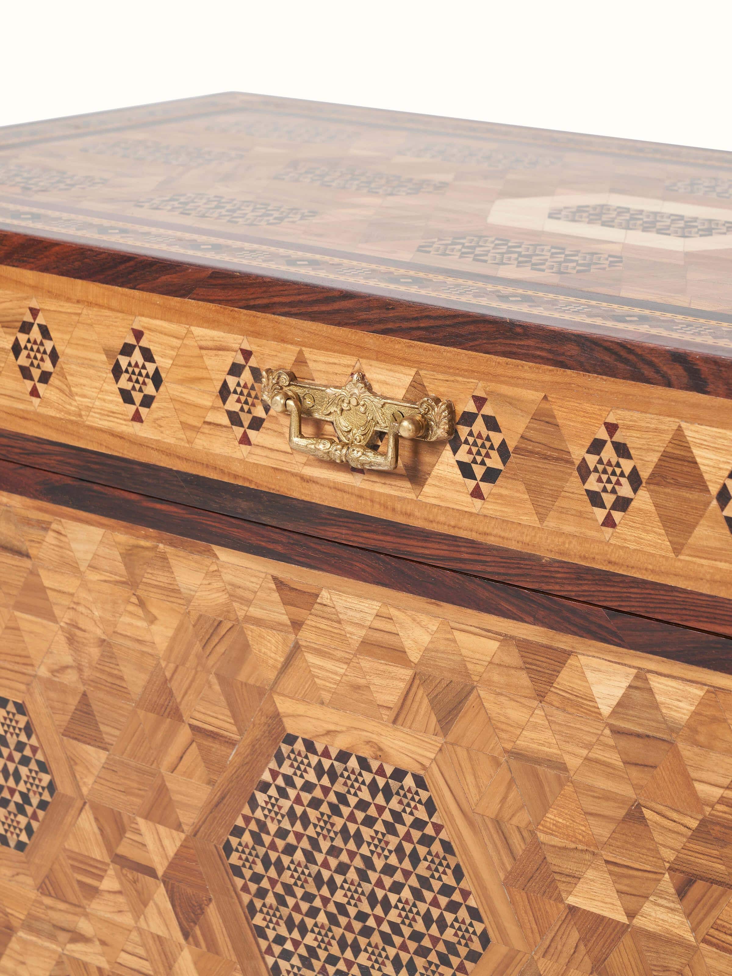 Close-up of the marquetry work on the teak wood trunk, emphasizing the intricate design and craftsmanship.