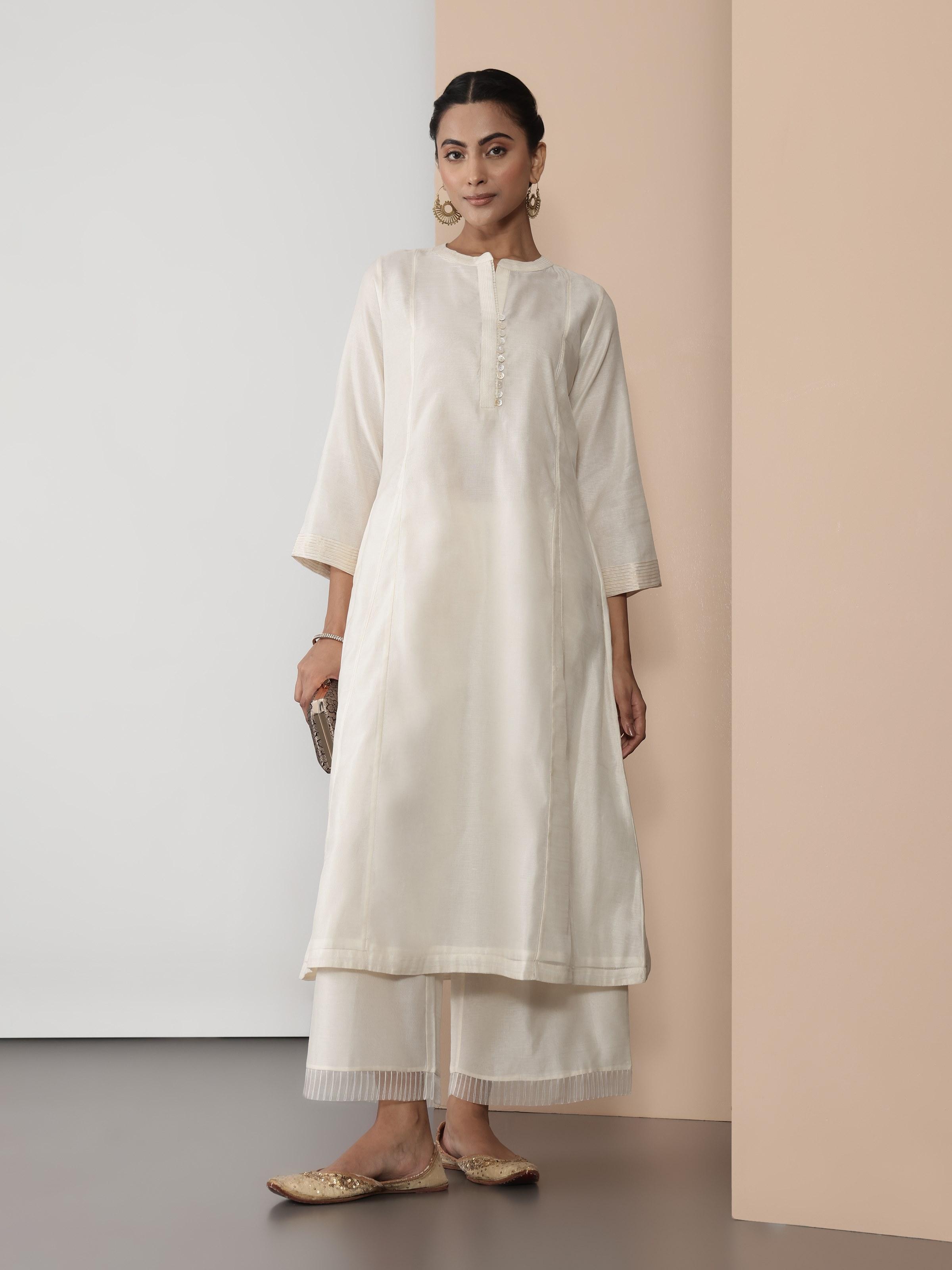 Lifestyle view of off-white Chanderi kurta styled with matching pants and traditional earrings.
