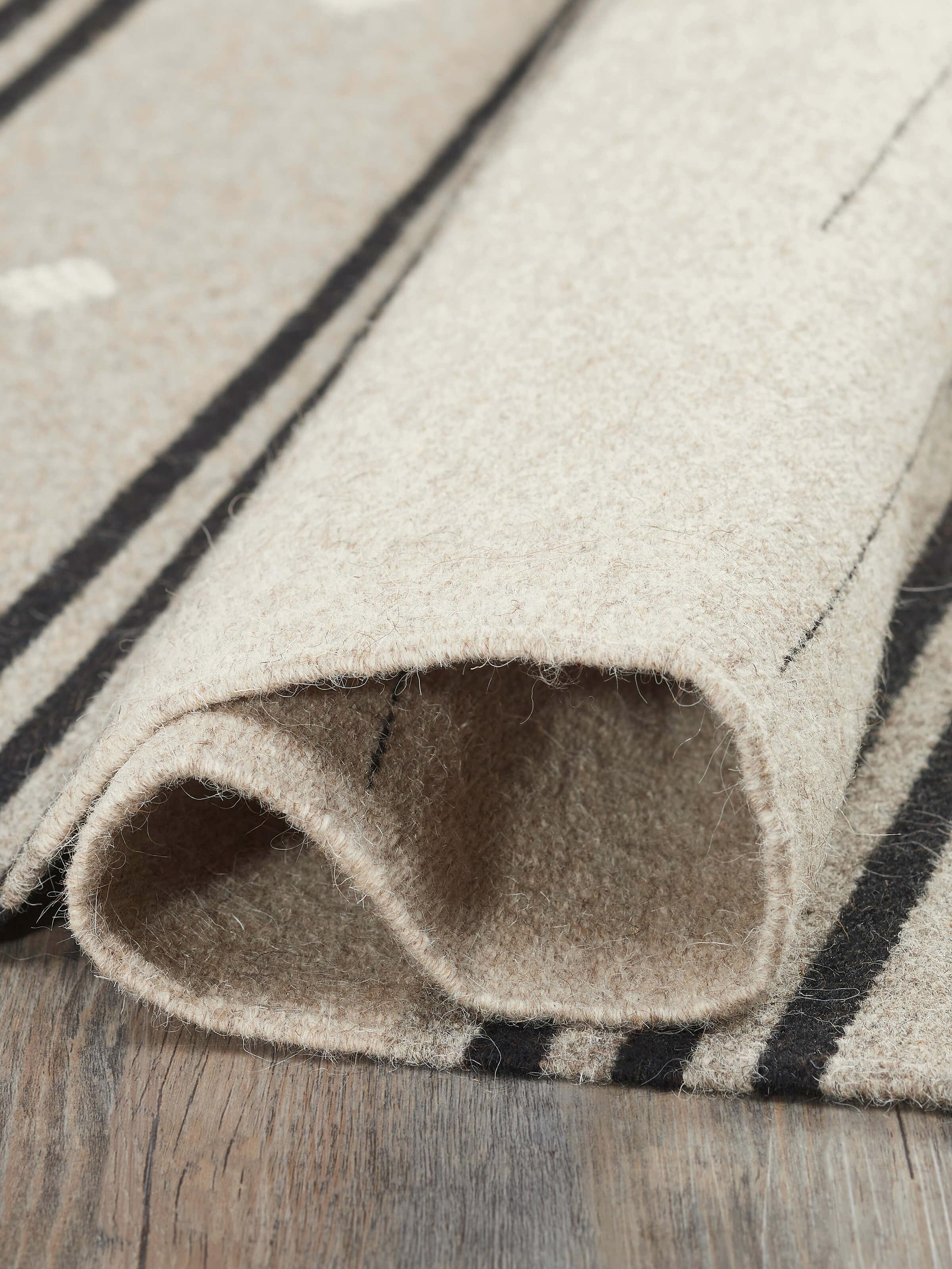 Close-up of Nomad stripes beige black Jawaja wool & cotton handloom dhurrie (3x5 ft) highlighting the fabric texture and stripe pattern