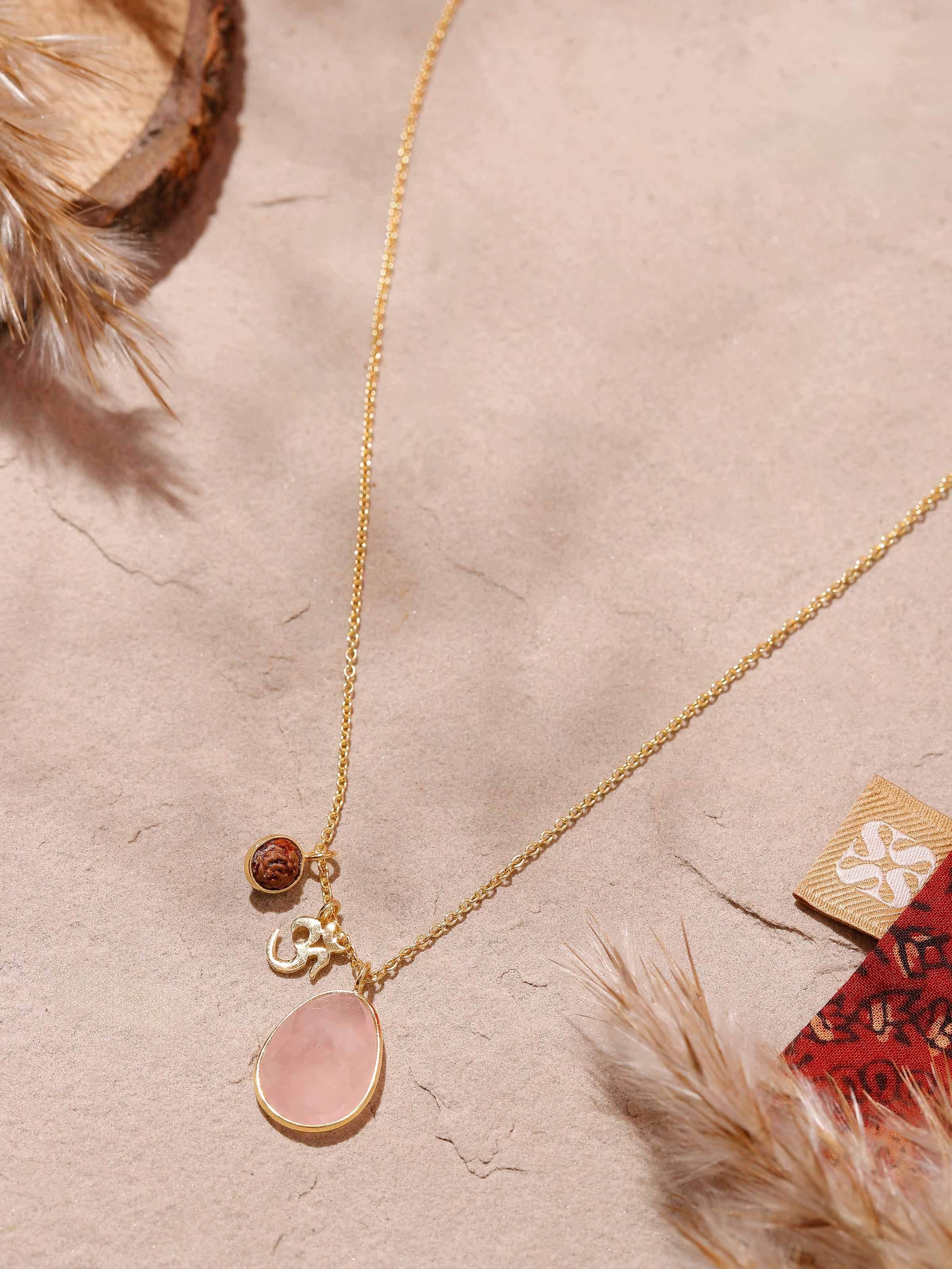 Side view of Rudraksha, Om Charm & Rose Quartz Necklace displaying rose quartz beads and intricate gold finish