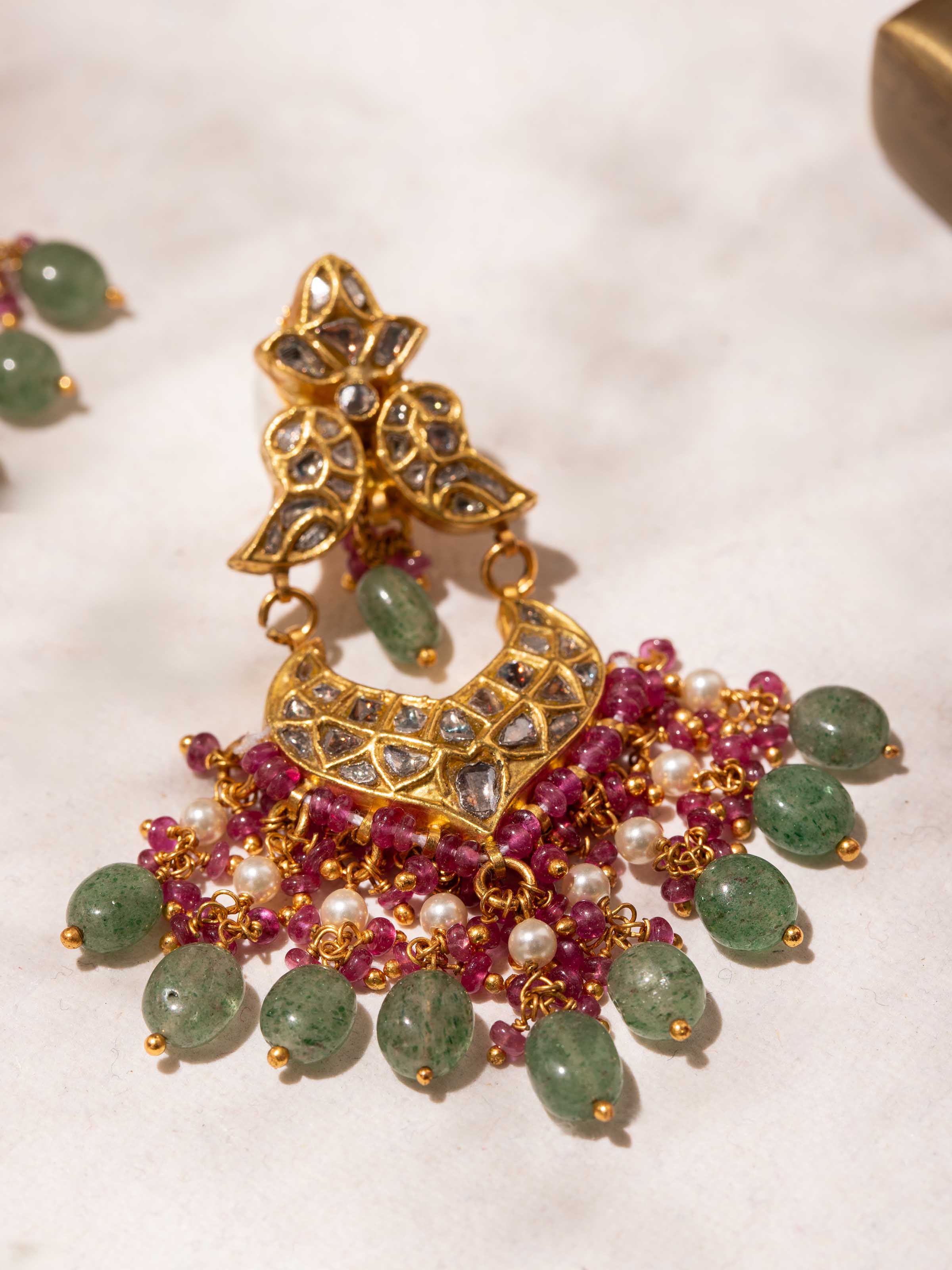 Close-up detail of the gold texture and patterns on Thappa drop earrings