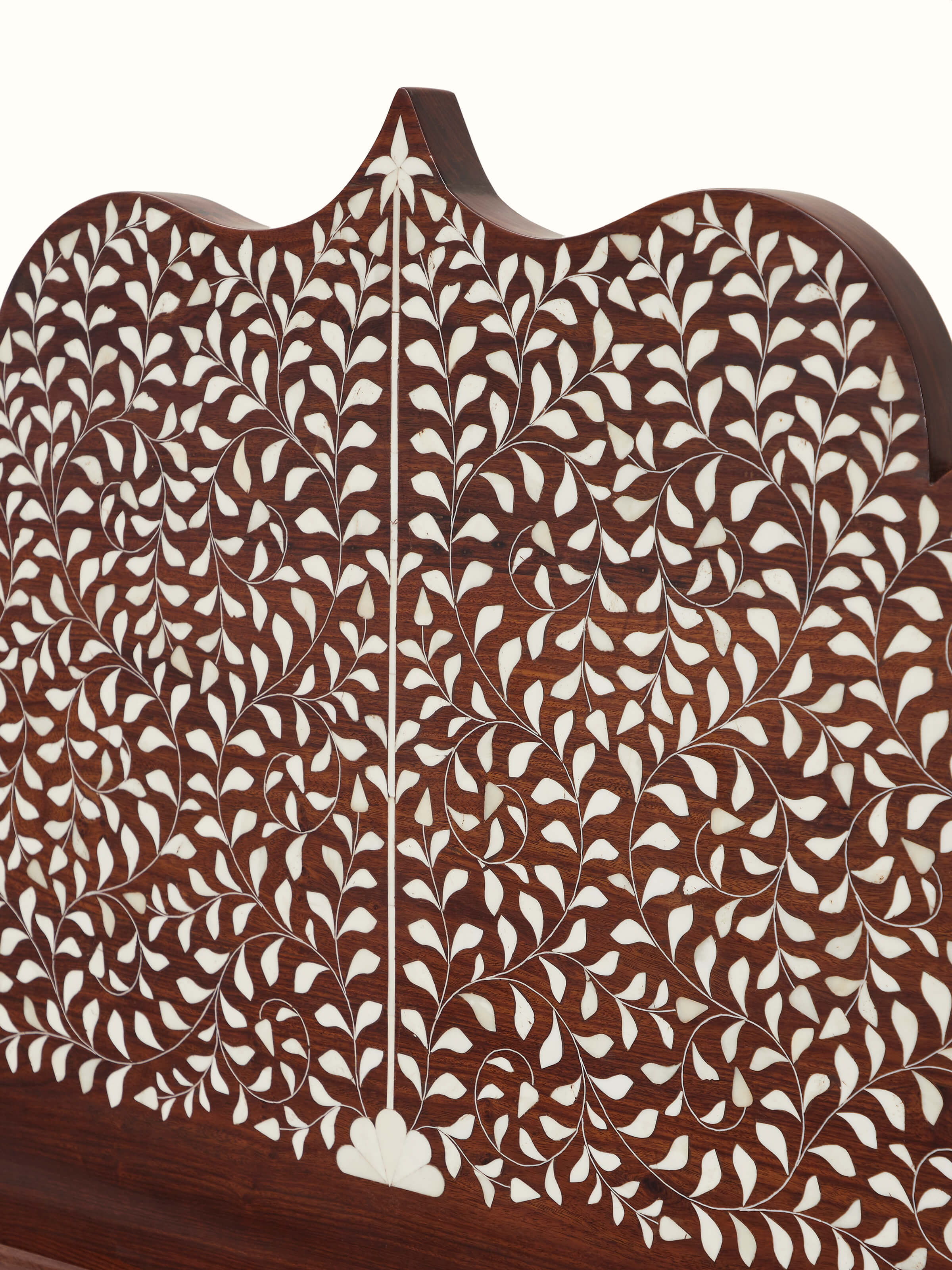 Close-up of bone inlay patterns on Sheesham wood king size bed, emphasizing intricate and luxurious details.