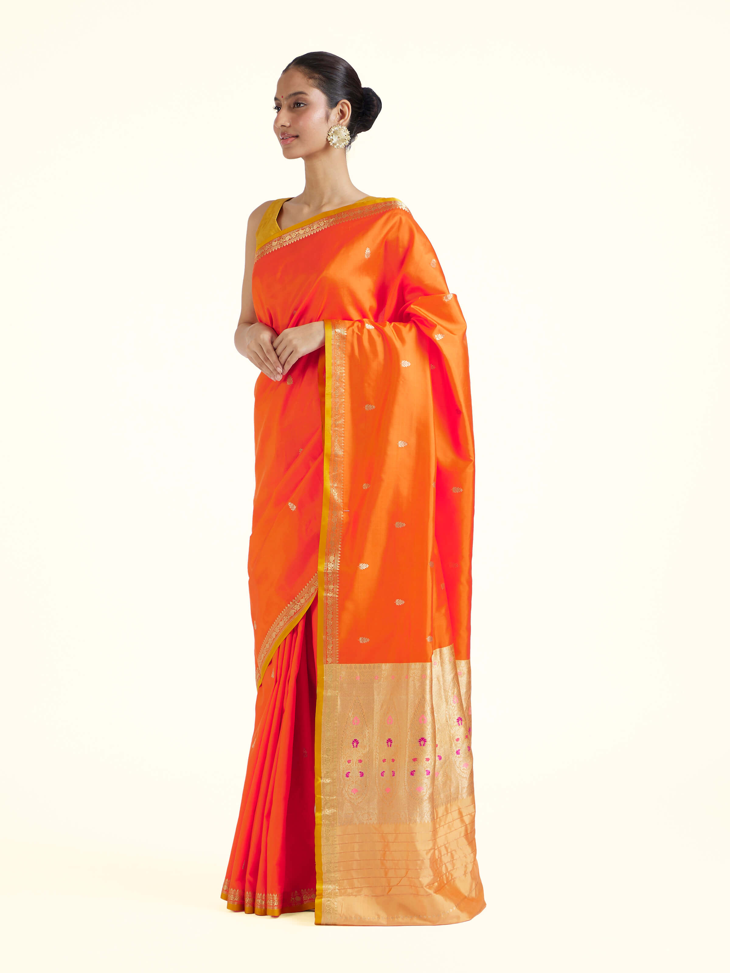 Side view of orange mulberry katan silk Banarasi saree with elegant drape and border