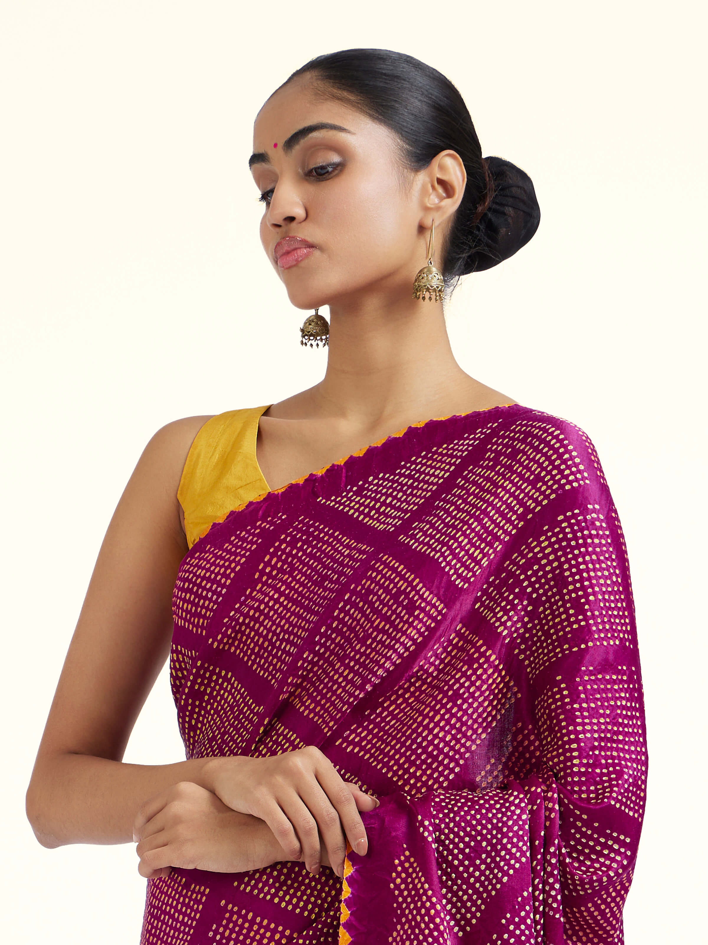 Angled view of purple silk tie and dye Bandhani saree highlighting Bandhani work