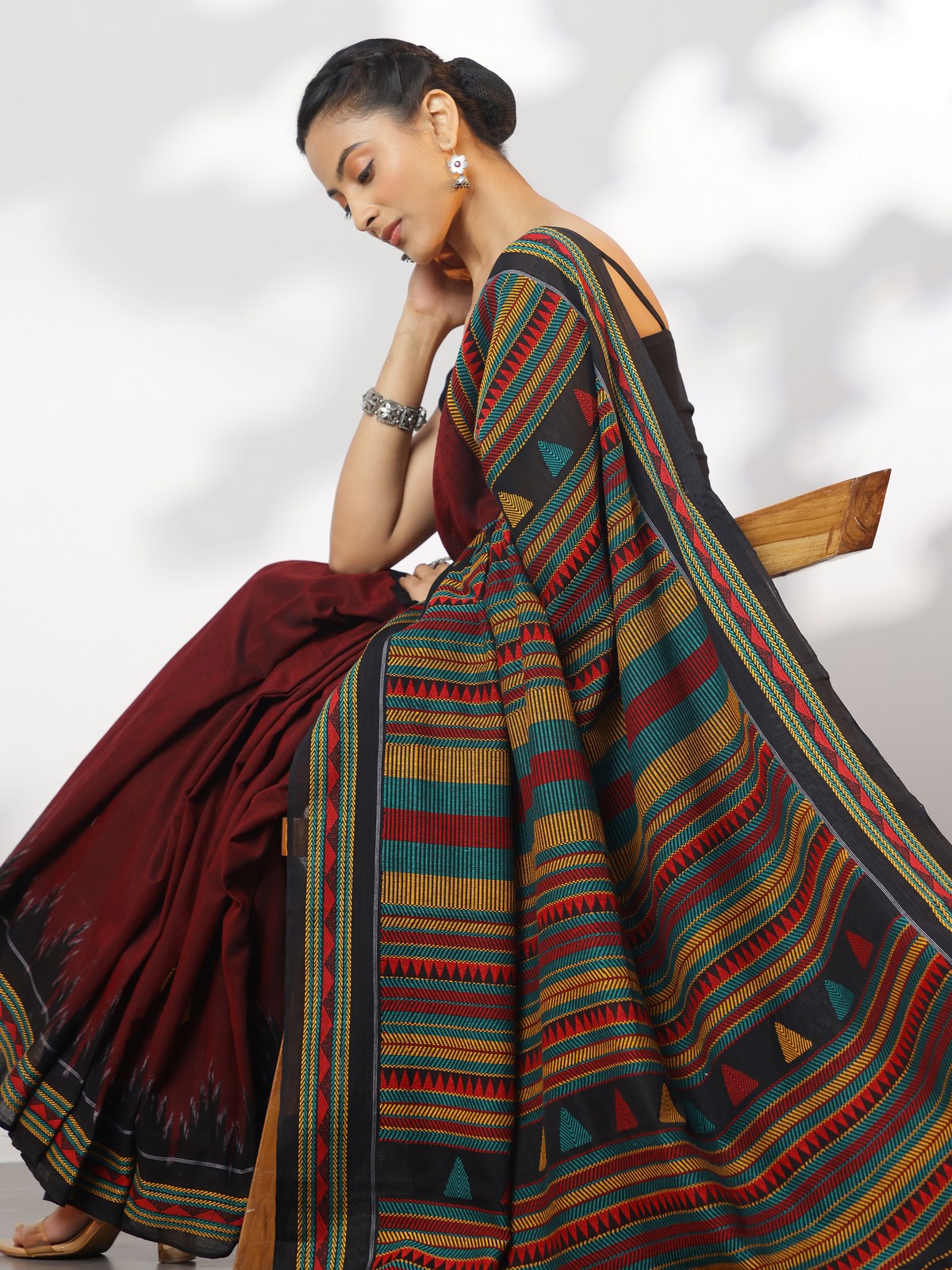 Angled lifestyle view showcasing red Dongaria cotton saree with contrast border and tribal design