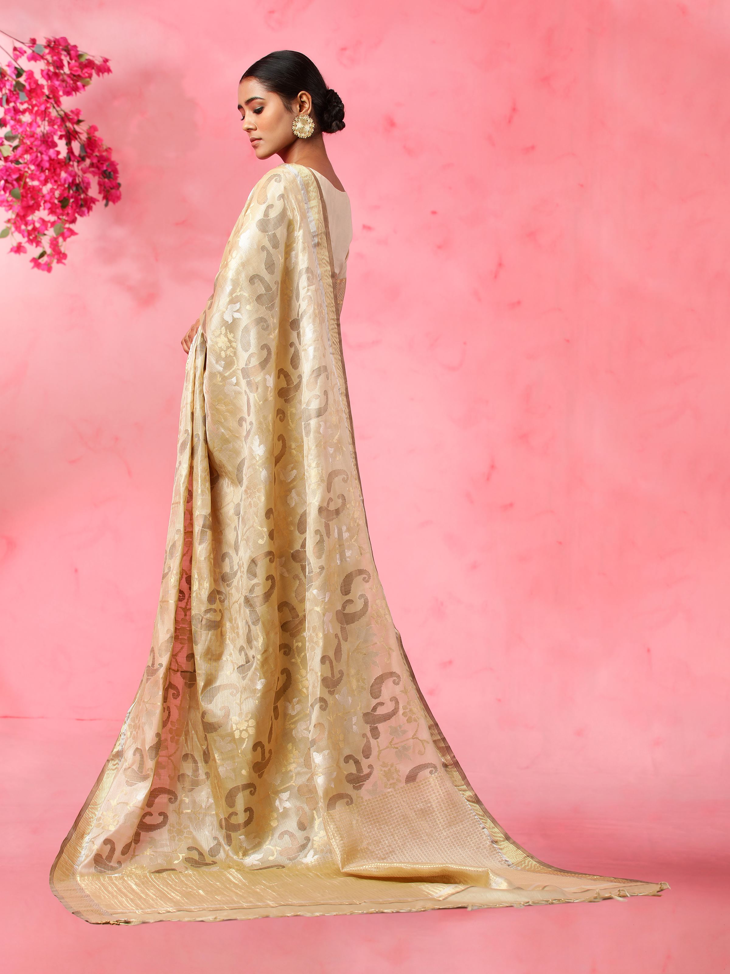 Close-up of beige tussar silk saree fabric highlighting subtle sheen and weave detail