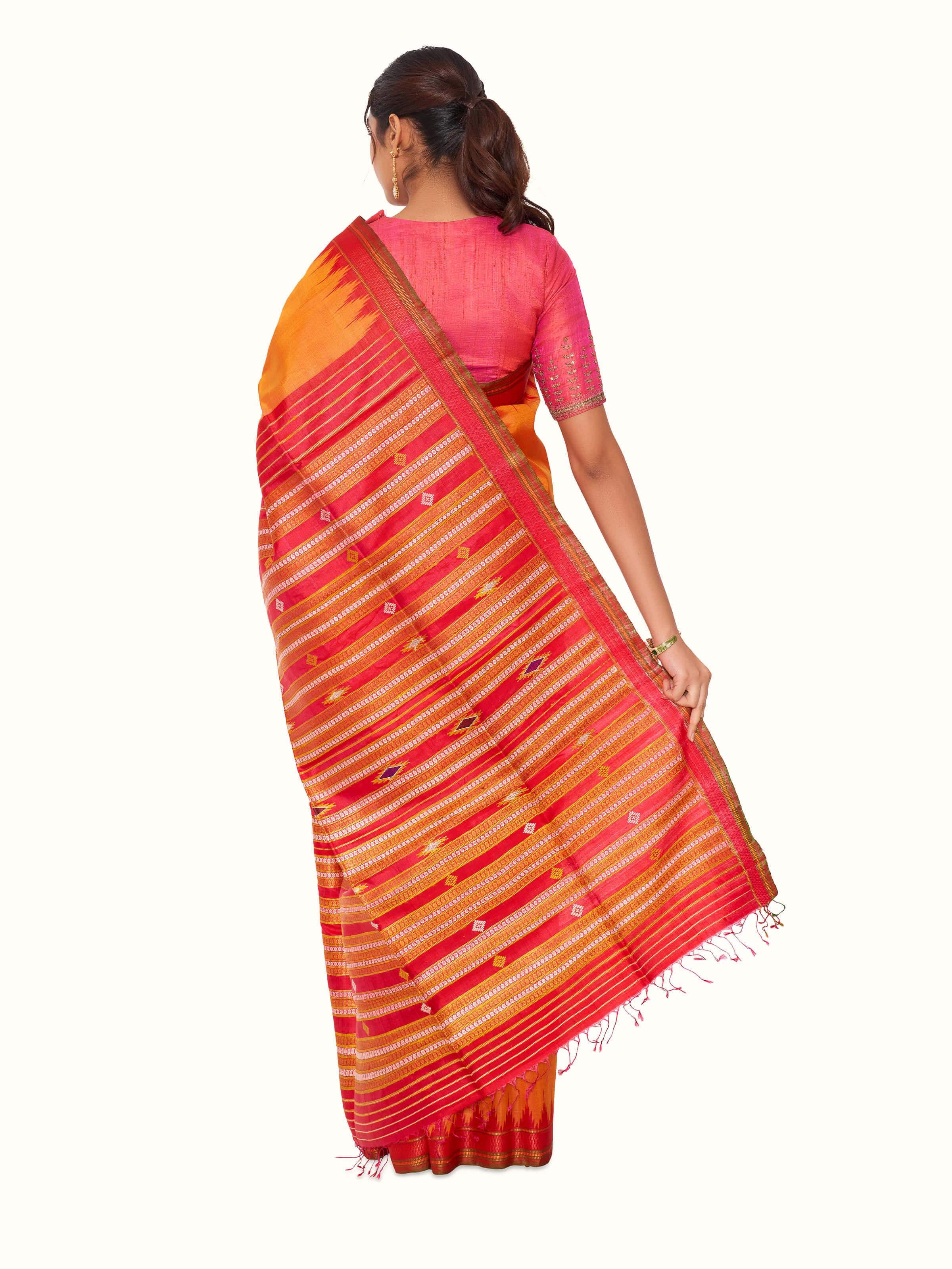 Detailed view of orange tussar silk bandha Odisha ikat saree emphasizing quality of fabric and ikat work