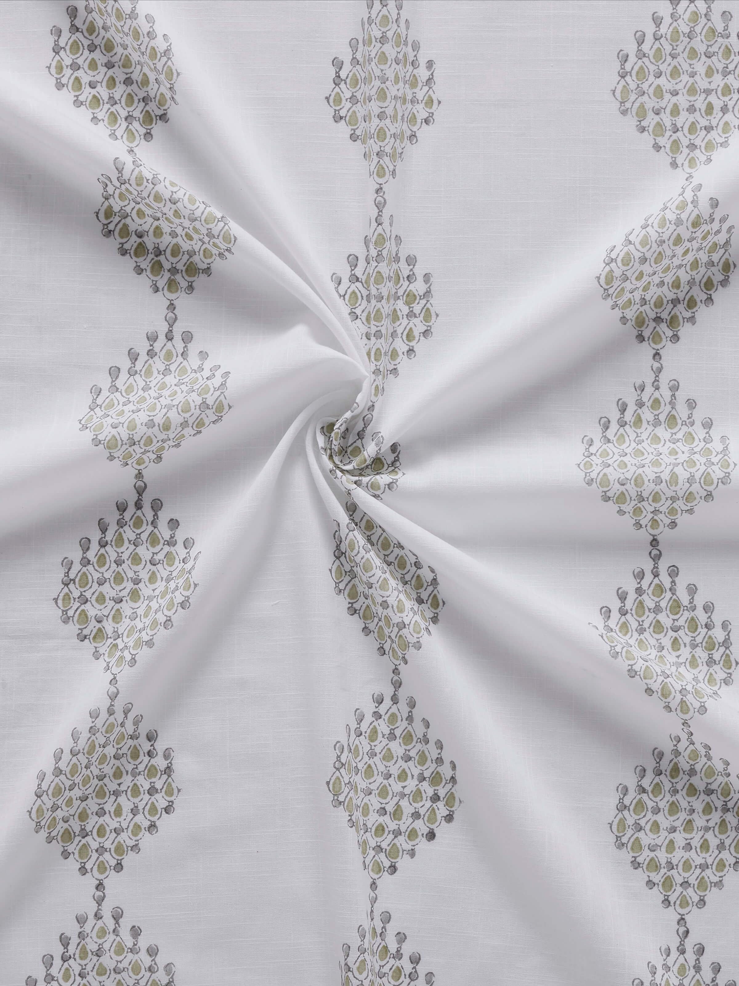Closer view of block printing technique on white curtain with green geo motifs.